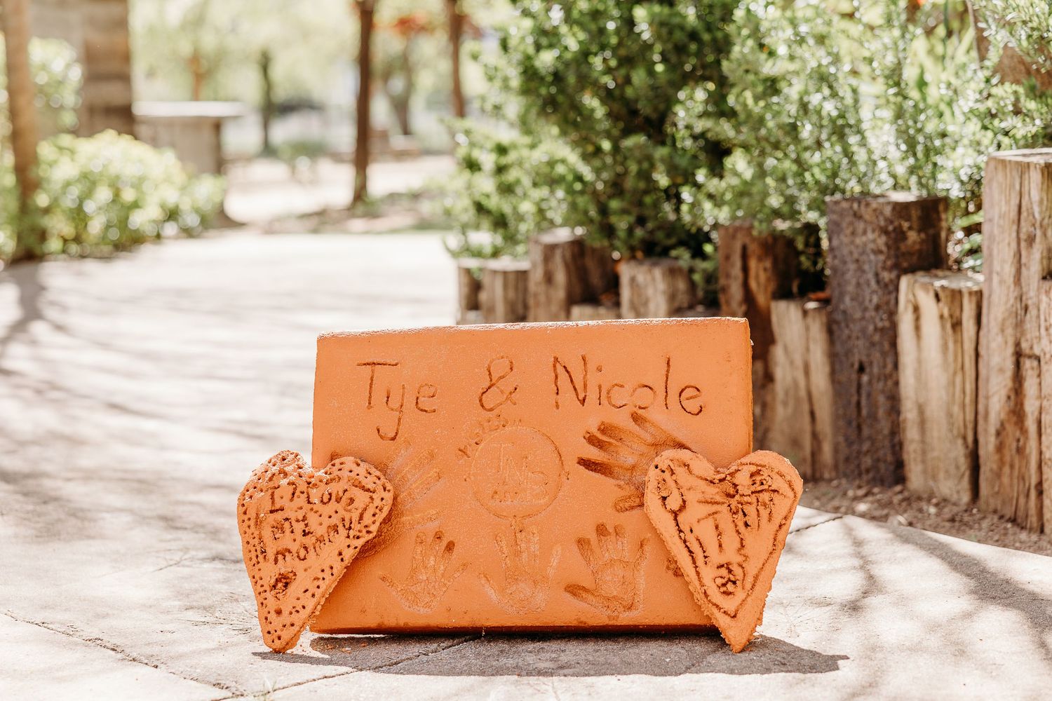 Terracotta clay sign with heart decorations displaying names Tye & Nicole.