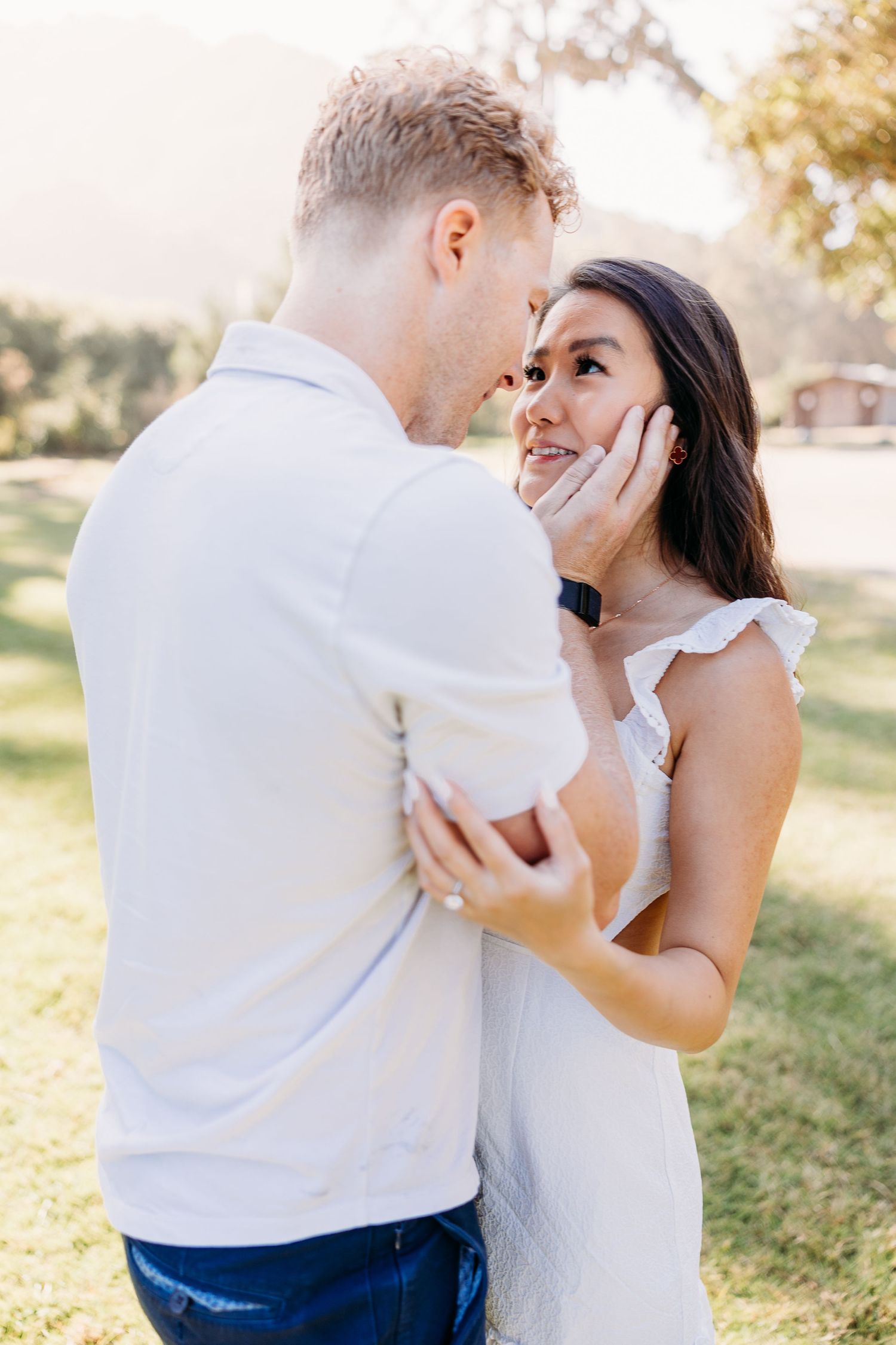 Romantic couple sharing an intimate moment in a sunny outdoor setting.