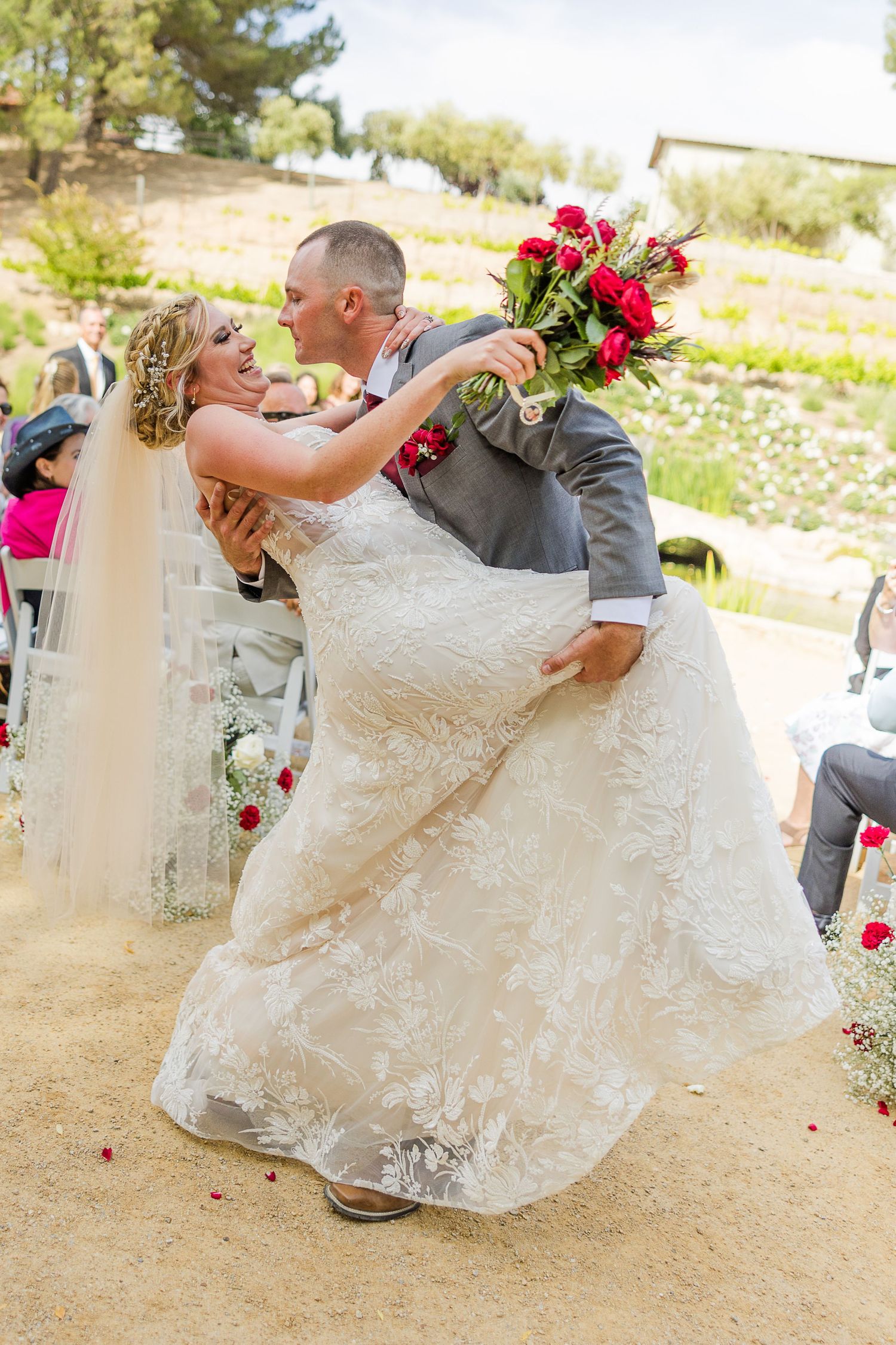 Romantic dip pose during wedding celebration on garden path.