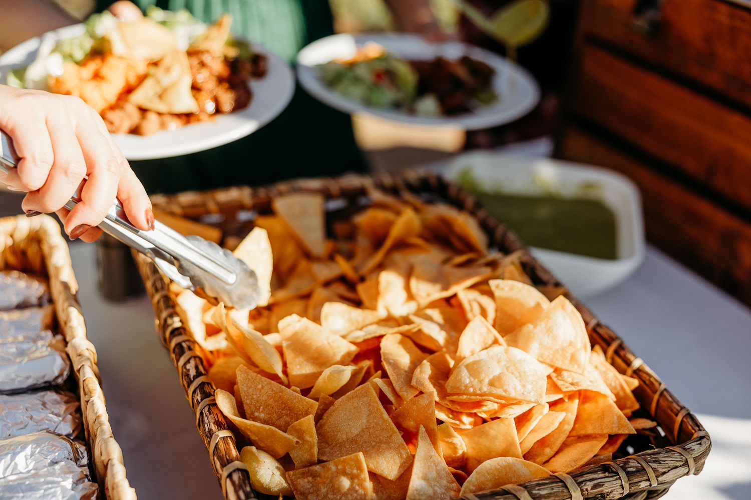 Appetizer platters with chips and snacks arranged on wooden serving boards.