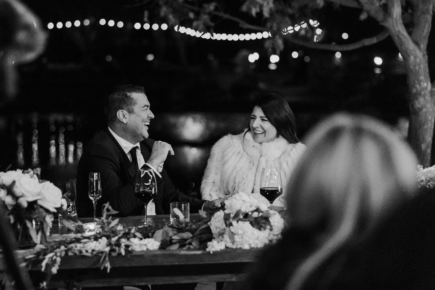 Intimate wedding reception scene with bokeh lights creating a romantic atmosphere.
