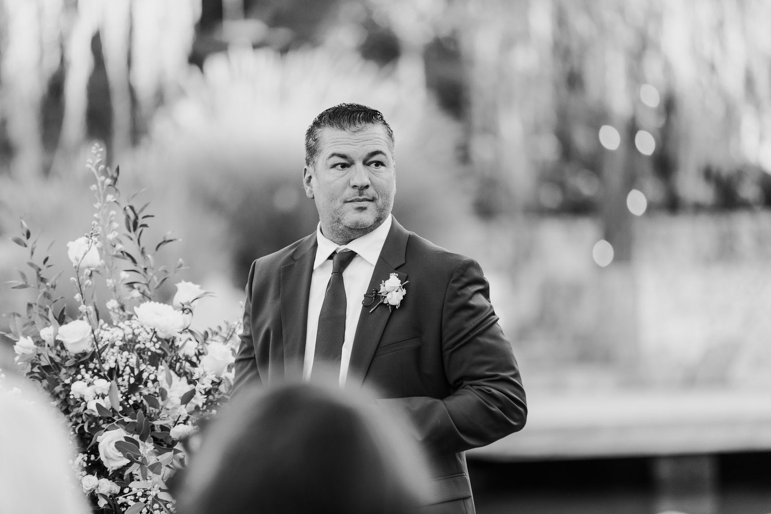 Black and white candid photo of a speech at an outdoor event.