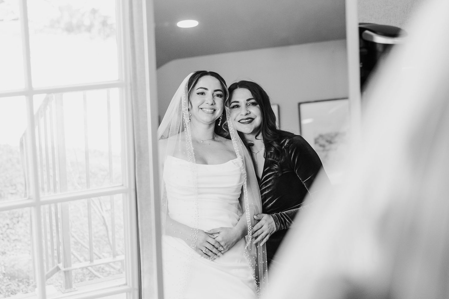 Black and white wedding photographs displayed in an elegant gallery wall arrangement with soft lighting.
