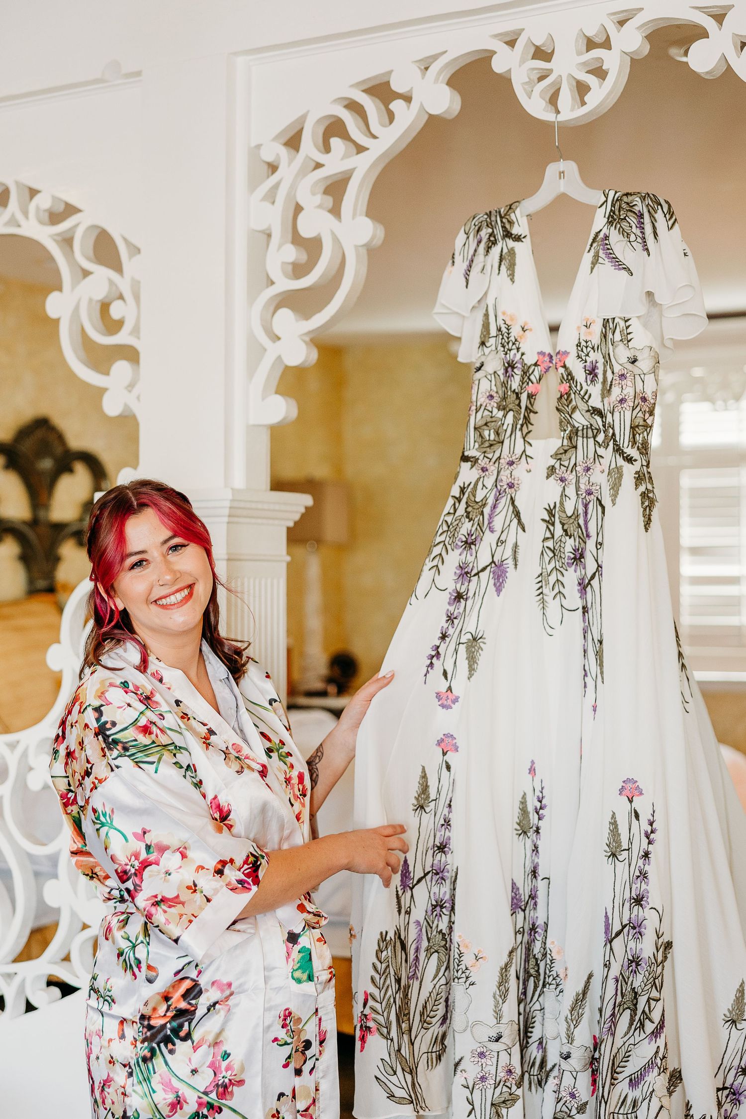 A floral kimono robe displayed in an elegant white room with ornate architectural details.