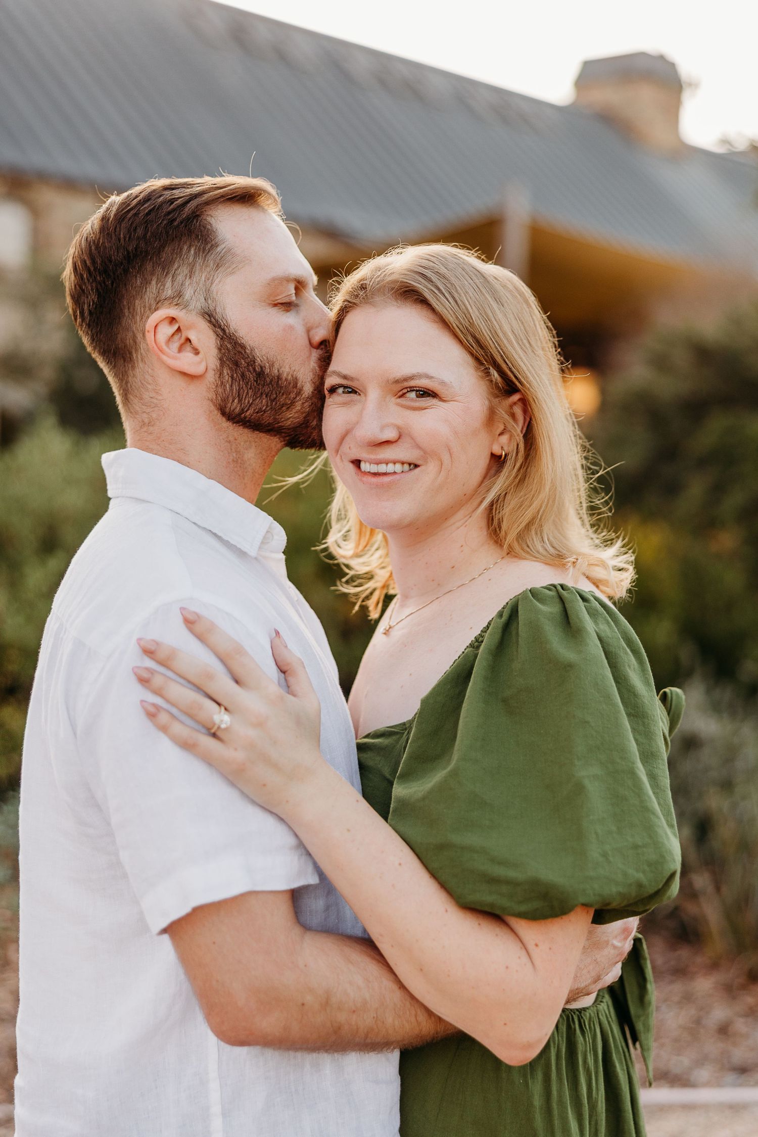 Intimate outdoor portrait session with couple embracing in golden evening light.