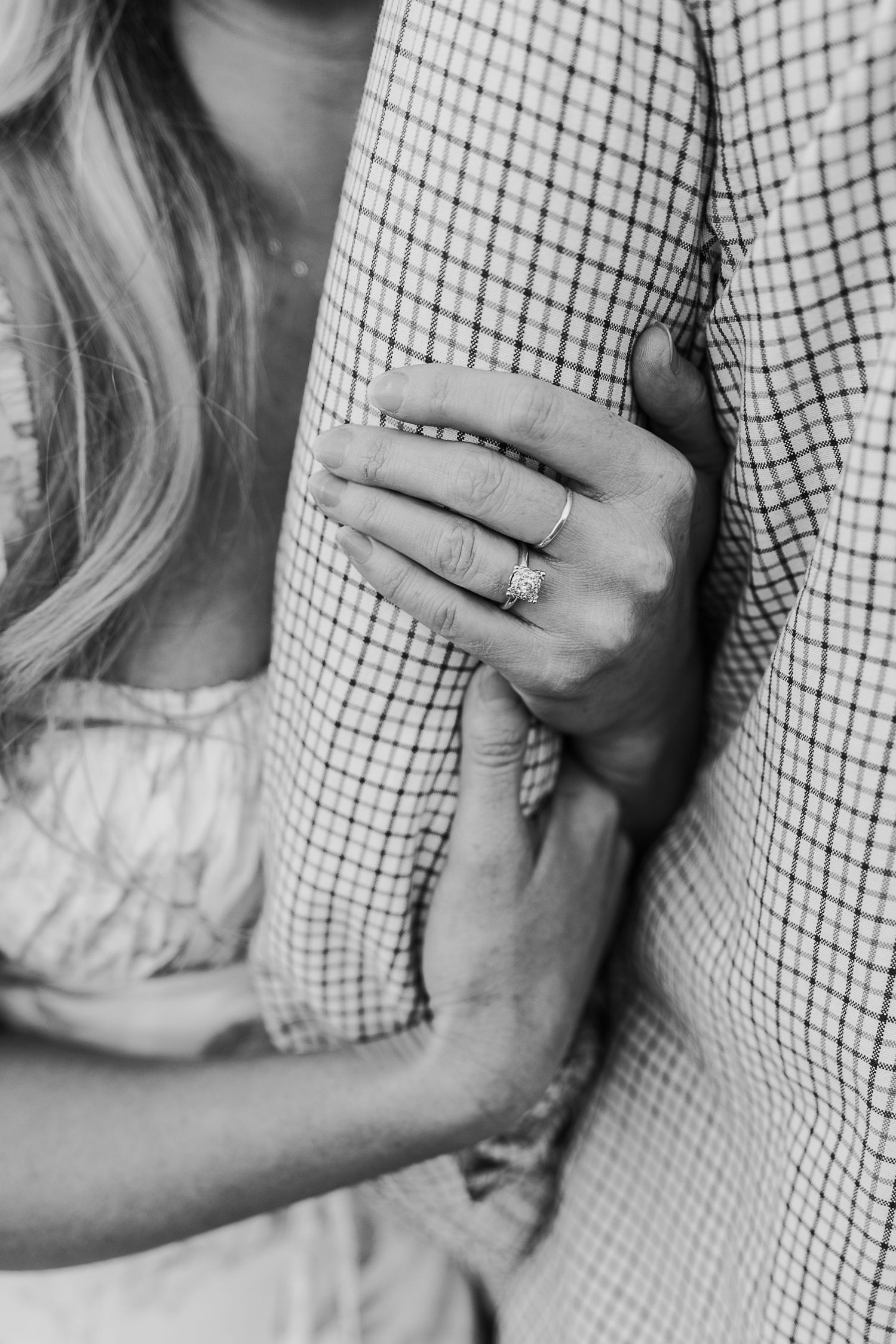 A black and white series of images showing hands against a checkered shirt and white bedding.