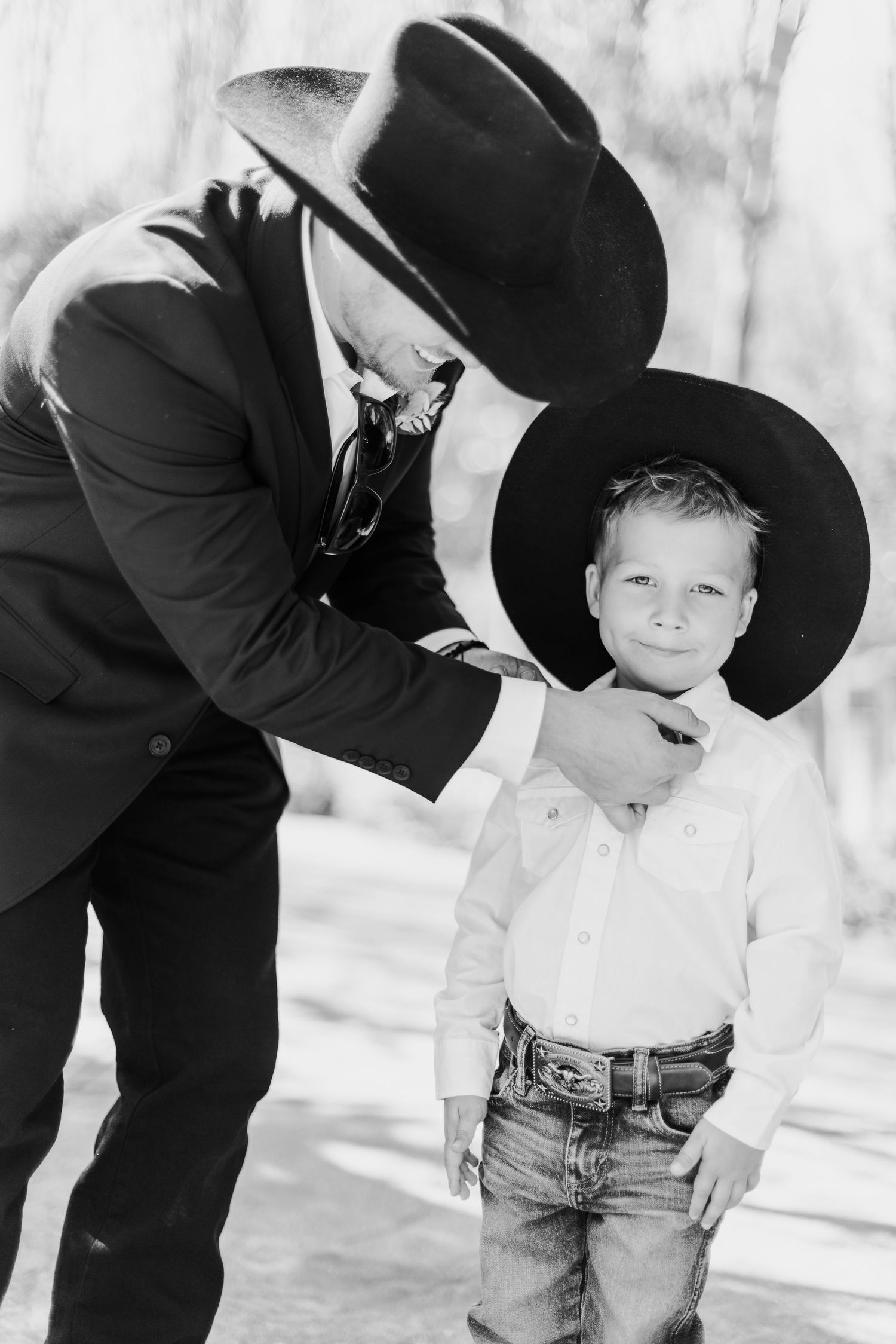 A black and white series shows sweet interactions between two people wearing cowboy hats.