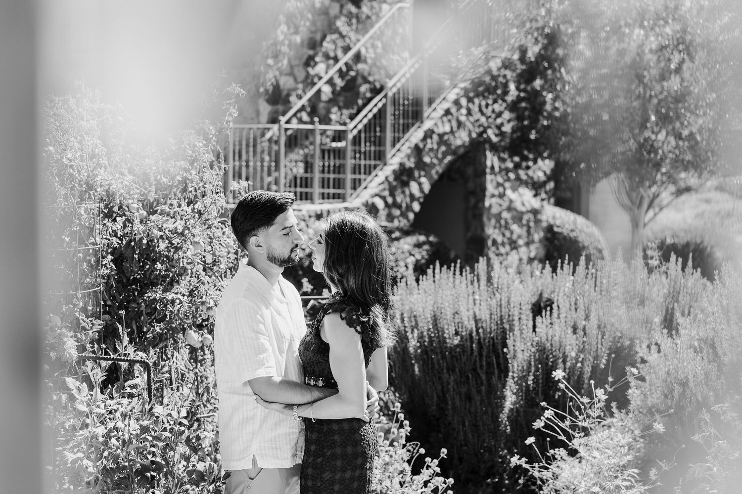 Silhouetted couple dancing together in a dreamy garden setting with soft bokeh lighting effects.