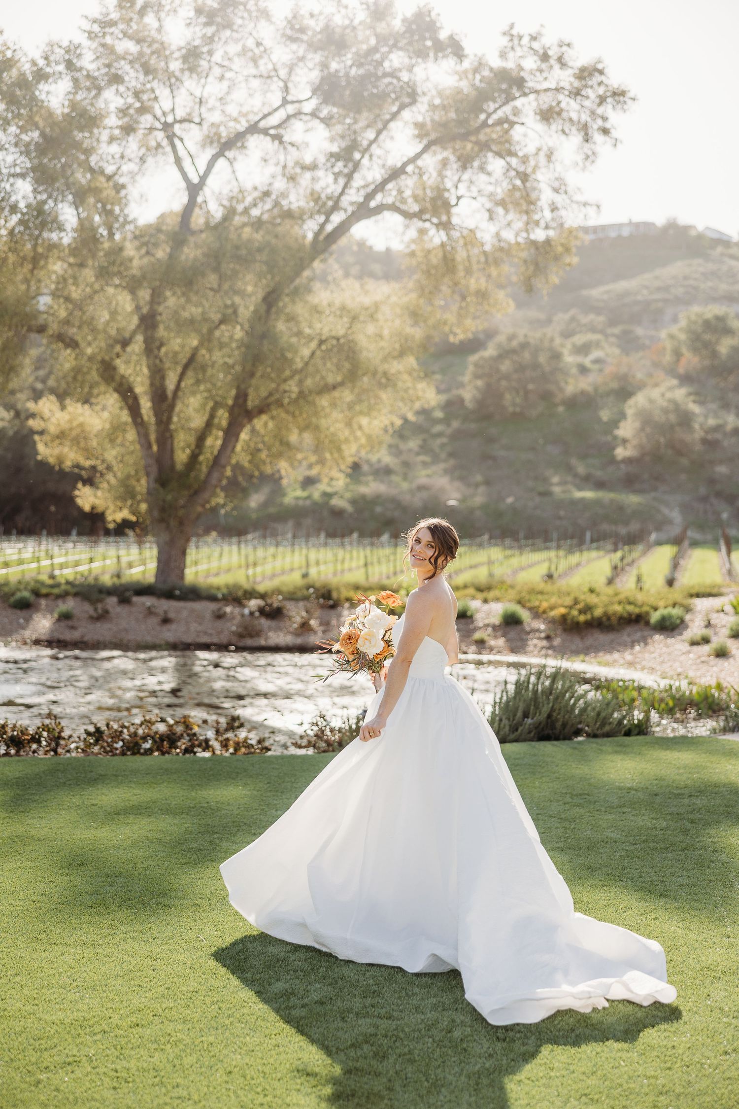 A flowing white wedding dress twirls gracefully across a sunlit garden lawn in a series of romantic motion shots.