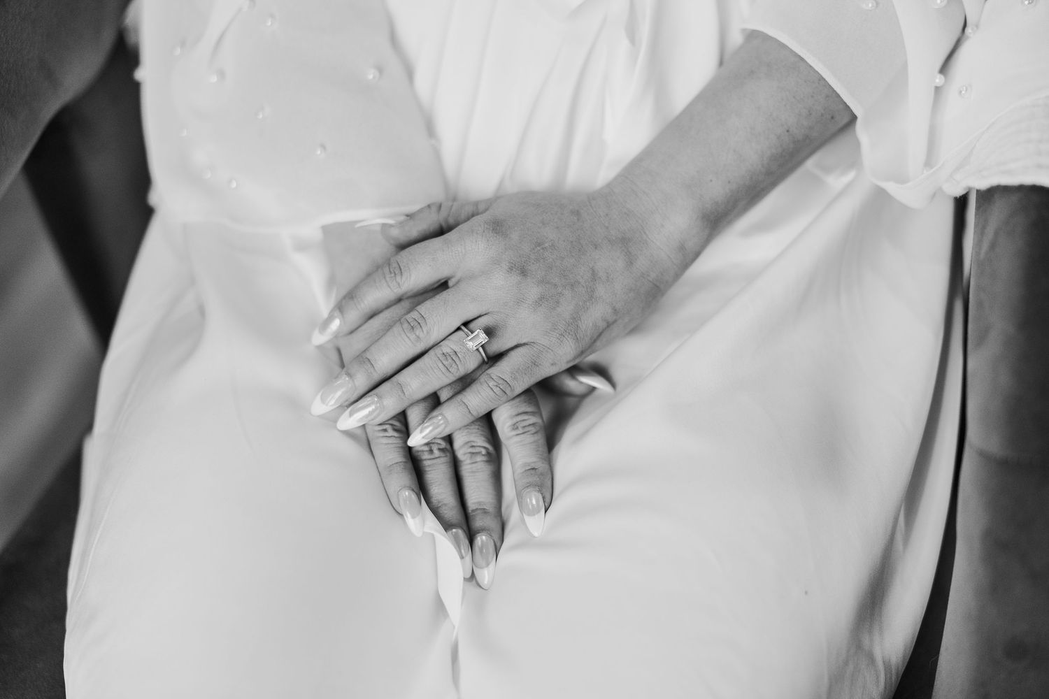 Close-up of white wedding dress details showing delicate fabric and texture.