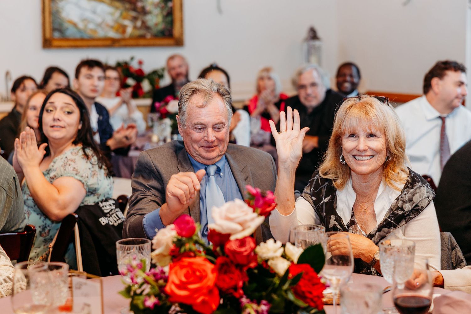 Wedding reception candid moments with guests laughing at decorated tables.