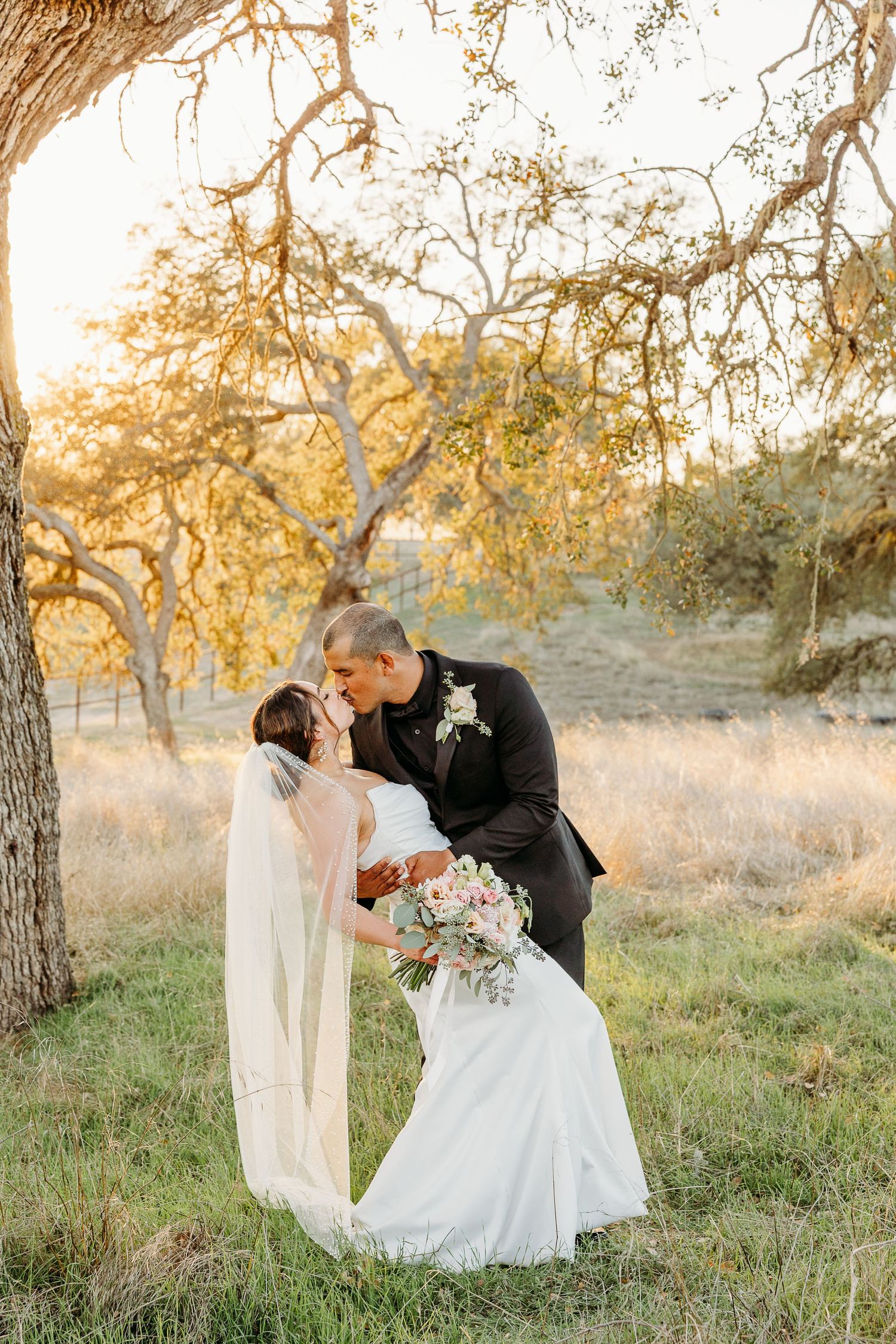 Romantic wedding dance sequence photographed under trees during golden hour.