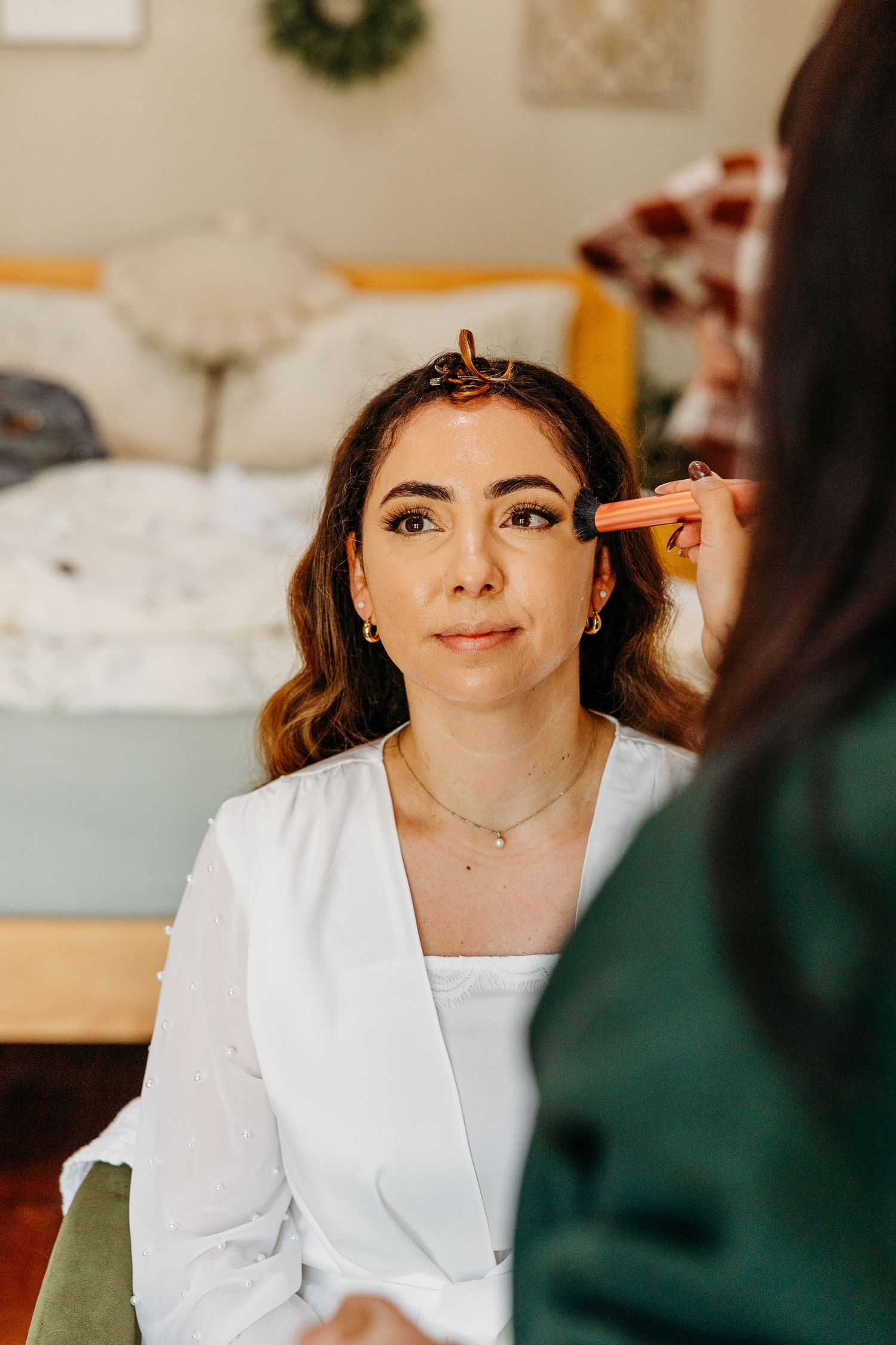 Wedding preparations with white bridal attire in a warmly lit indoor setting.