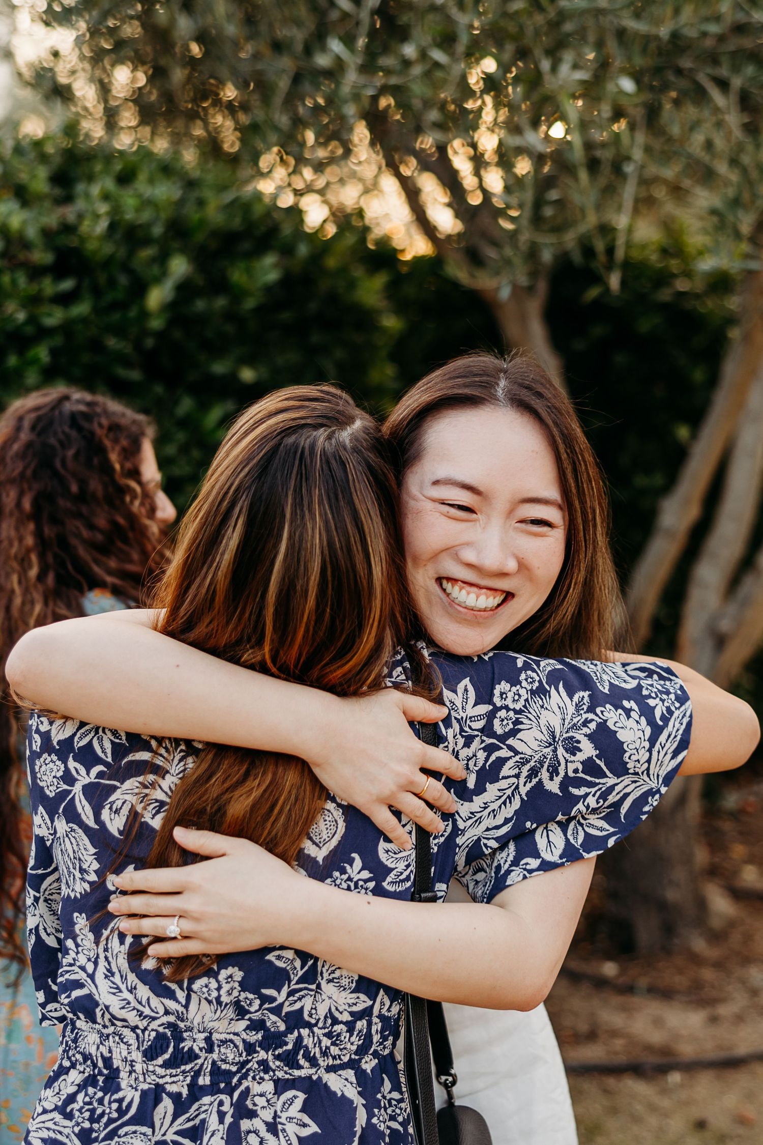 Friends sharing warm embraces and joyful moments outdoors during golden hour.