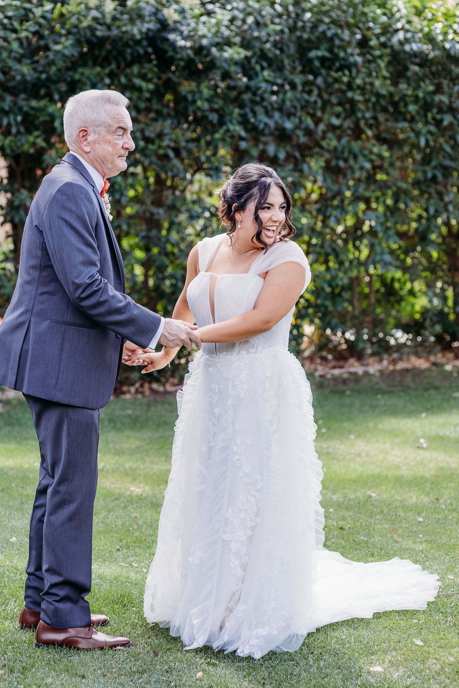 A couple shares a joyful moment during their outdoor wedding ceremony.