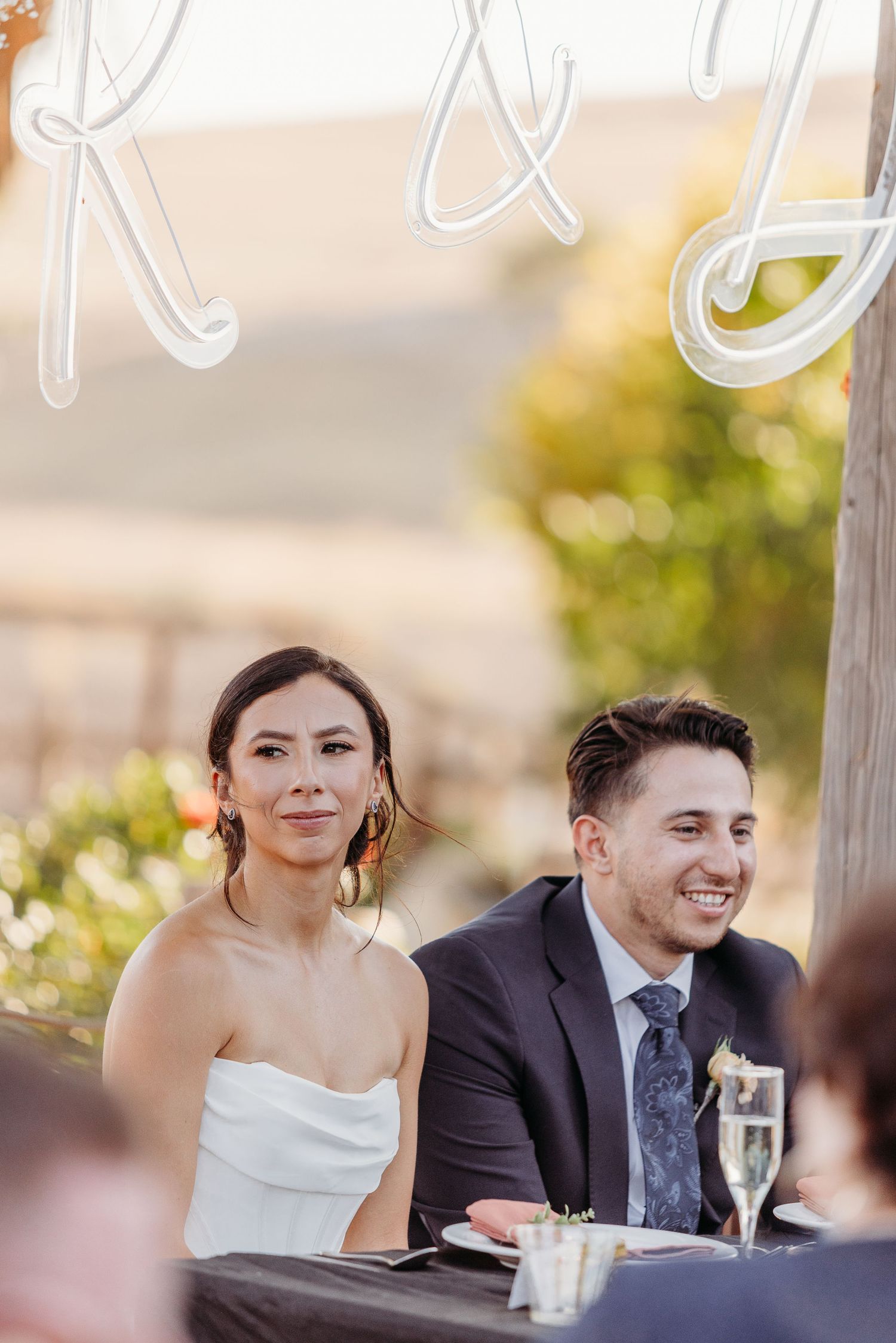 Wedding reception guests seated at tables with string lights overhead creating a romantic ambiance.