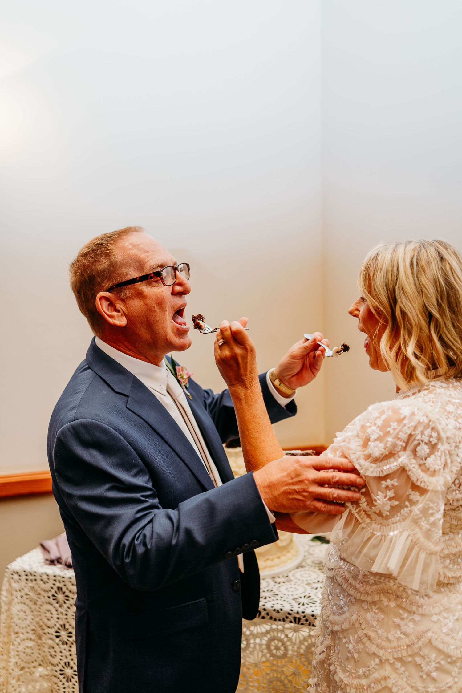Couple playfully feeds each other wedding cake in a series of four candid photos.