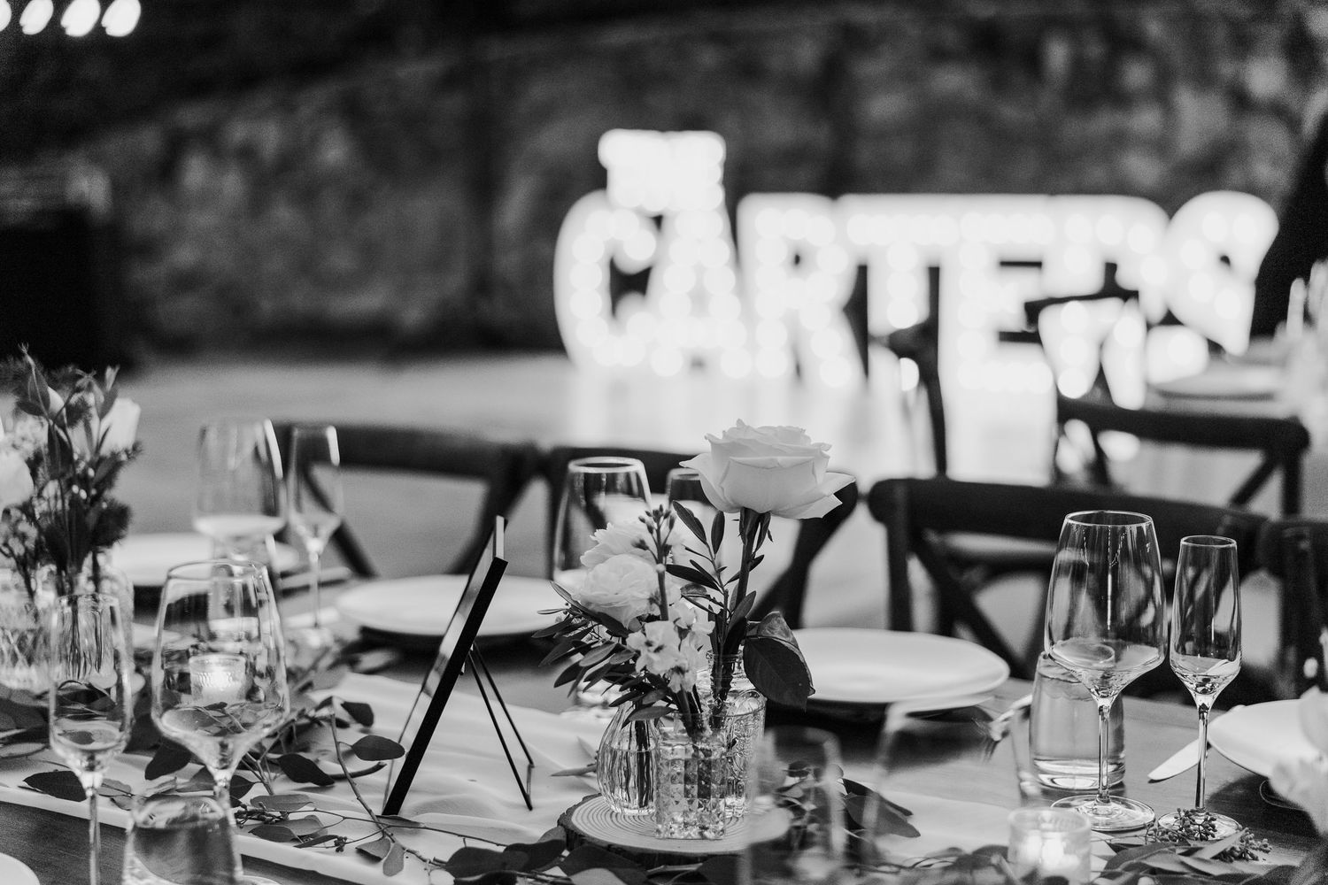 An elegant black and white wedding reception table setting with glassware and decorative elements.