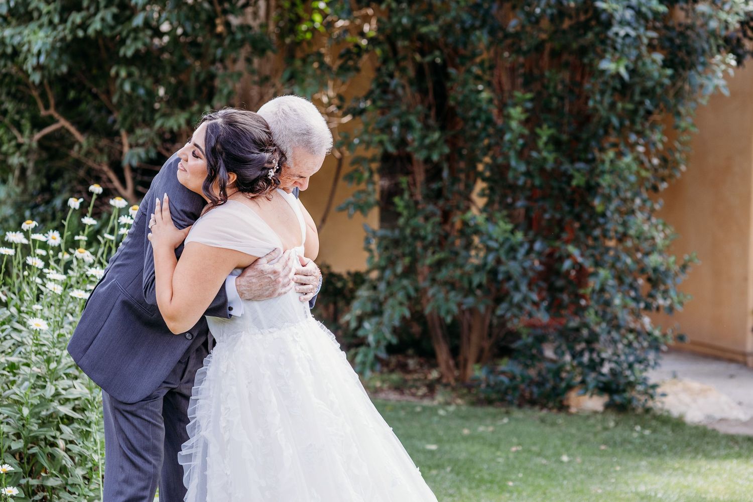 An intimate embrace between a couple during their garden wedding ceremony.