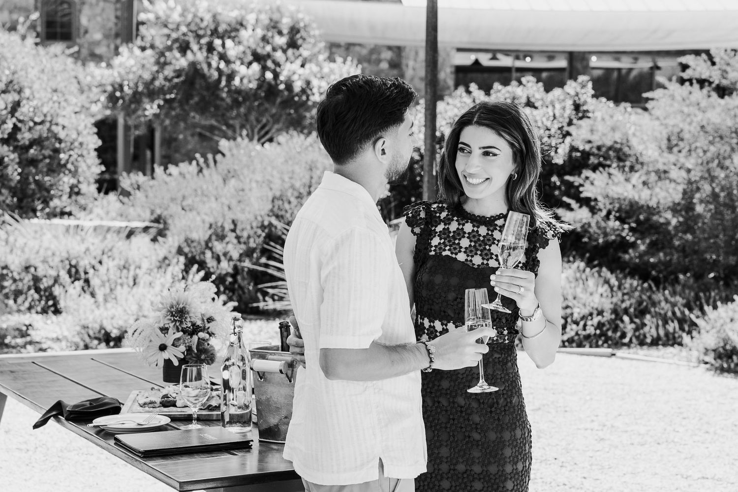 Black and white photograph of people gathering at an outdoor social event.