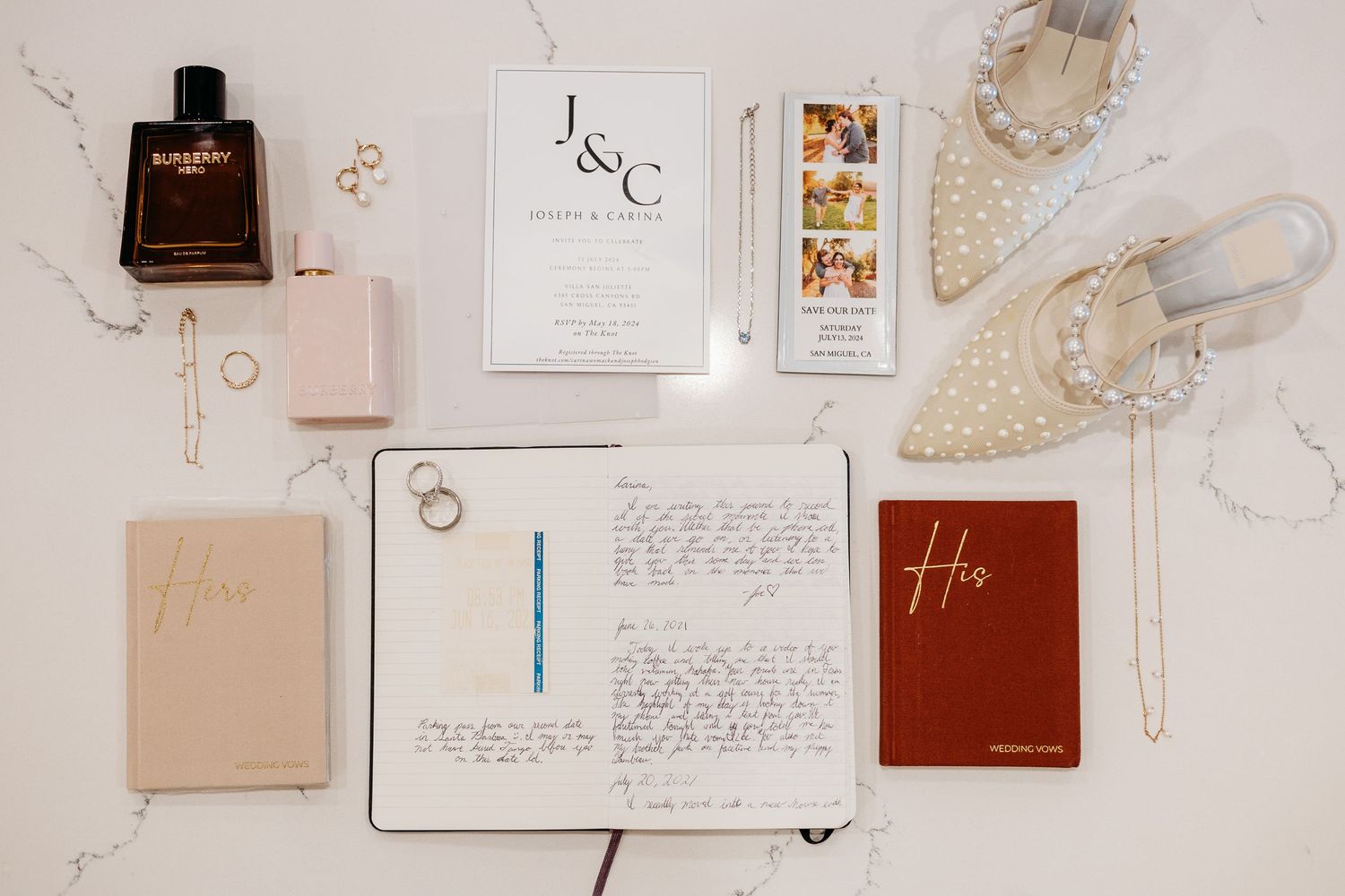 Wedding stationery and accessories flatlay including vow books, invitations, and pearl-adorned shoes.