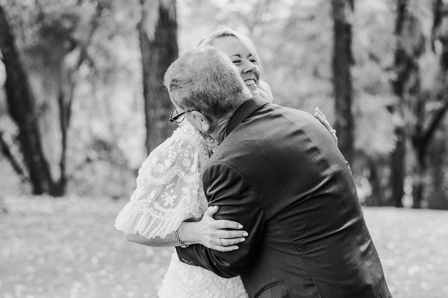 Emotional embrace captured in black and white photography outdoors.