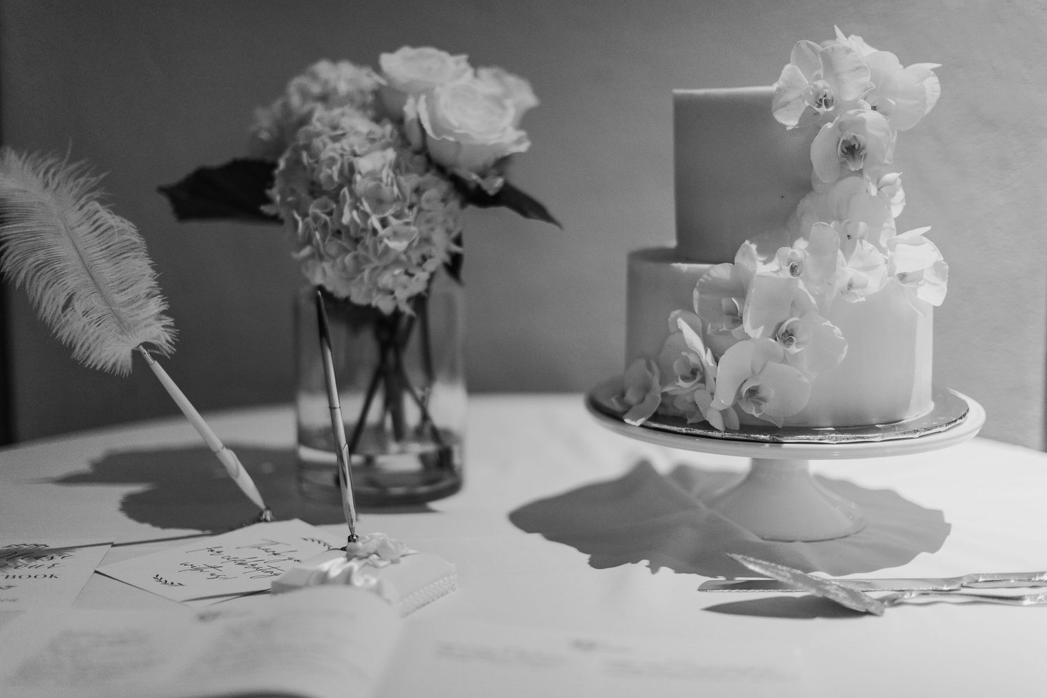 A black and white collage of wedding cake slices displayed on plates with floral decorations.