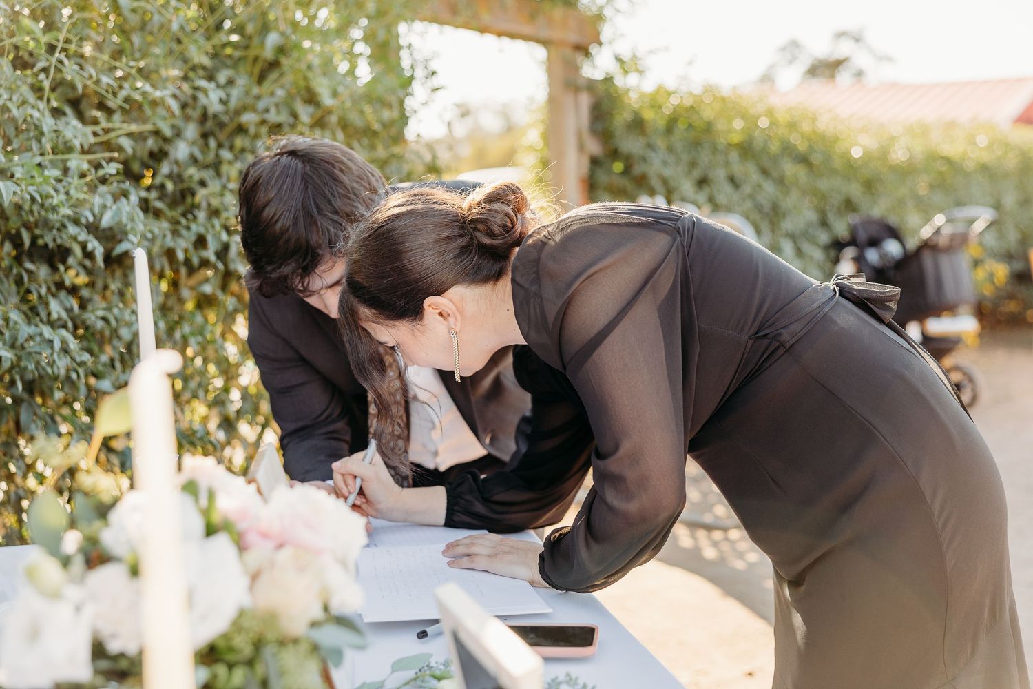 Candid moments captured at an outdoor wedding ceremony with guests and decorations in a garden setting.