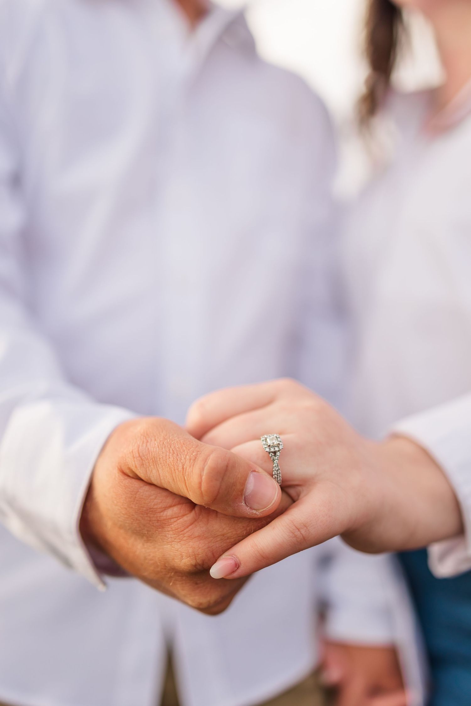Close up of hands with engagement ring showing romantic moment between couple.