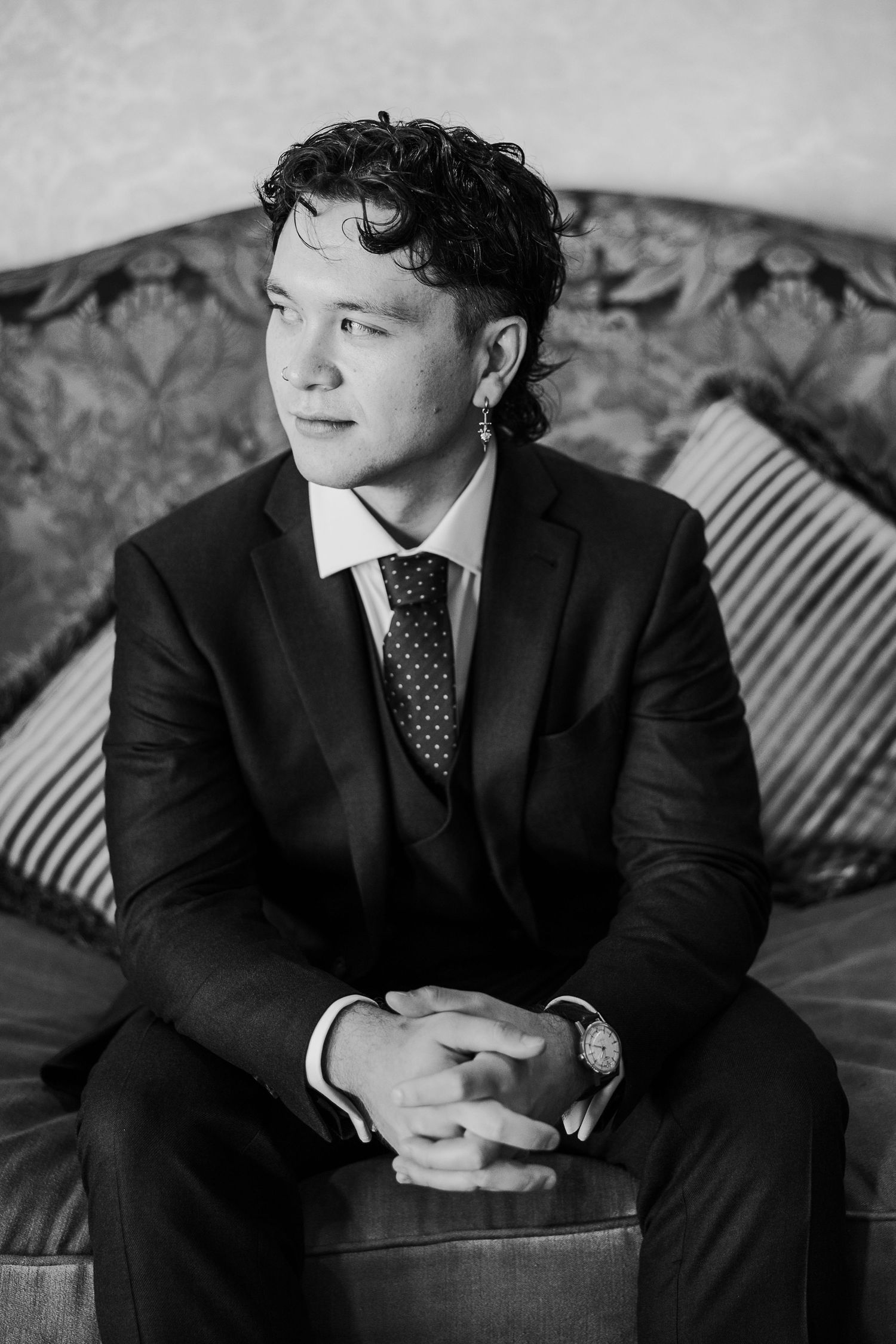 Black and white portrait series showing person in suit reclining on couch with decorative background.