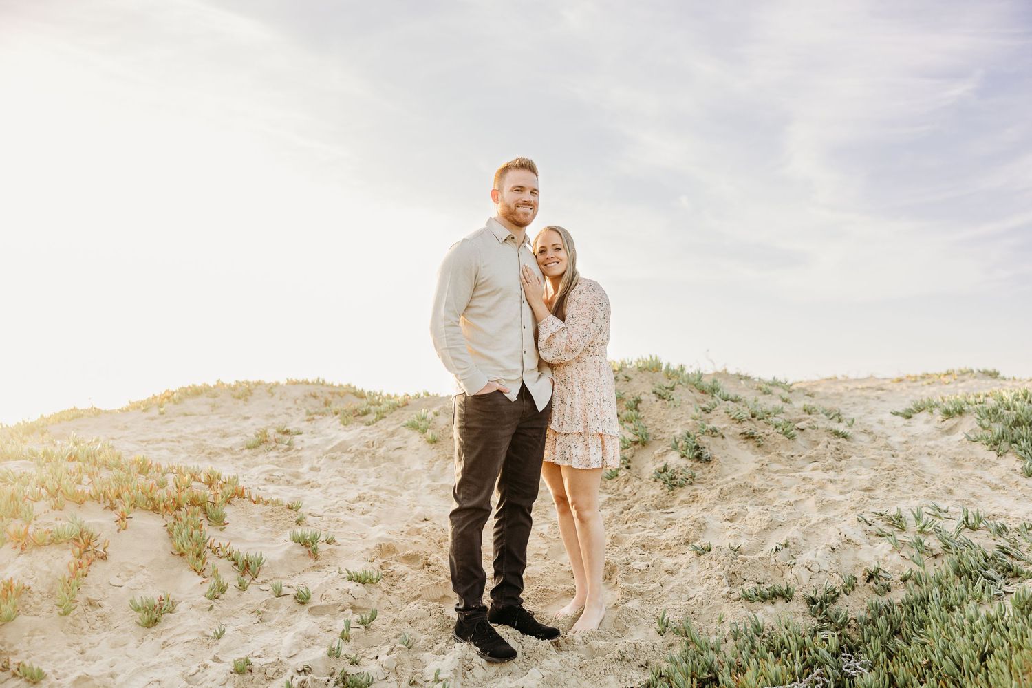 A romantic outdoor portrait with green hills and soft lighting in the background.