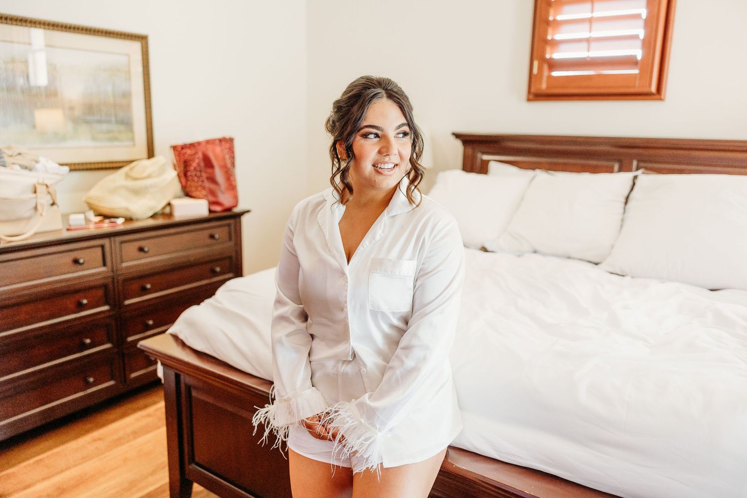 Morning wedding preparation scene in a bedroom with traditional wooden furniture.