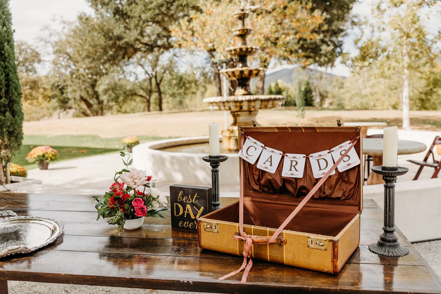 A rustic outdoor wedding venue with vintage wooden furniture and decorative banners arranged for a ceremony.