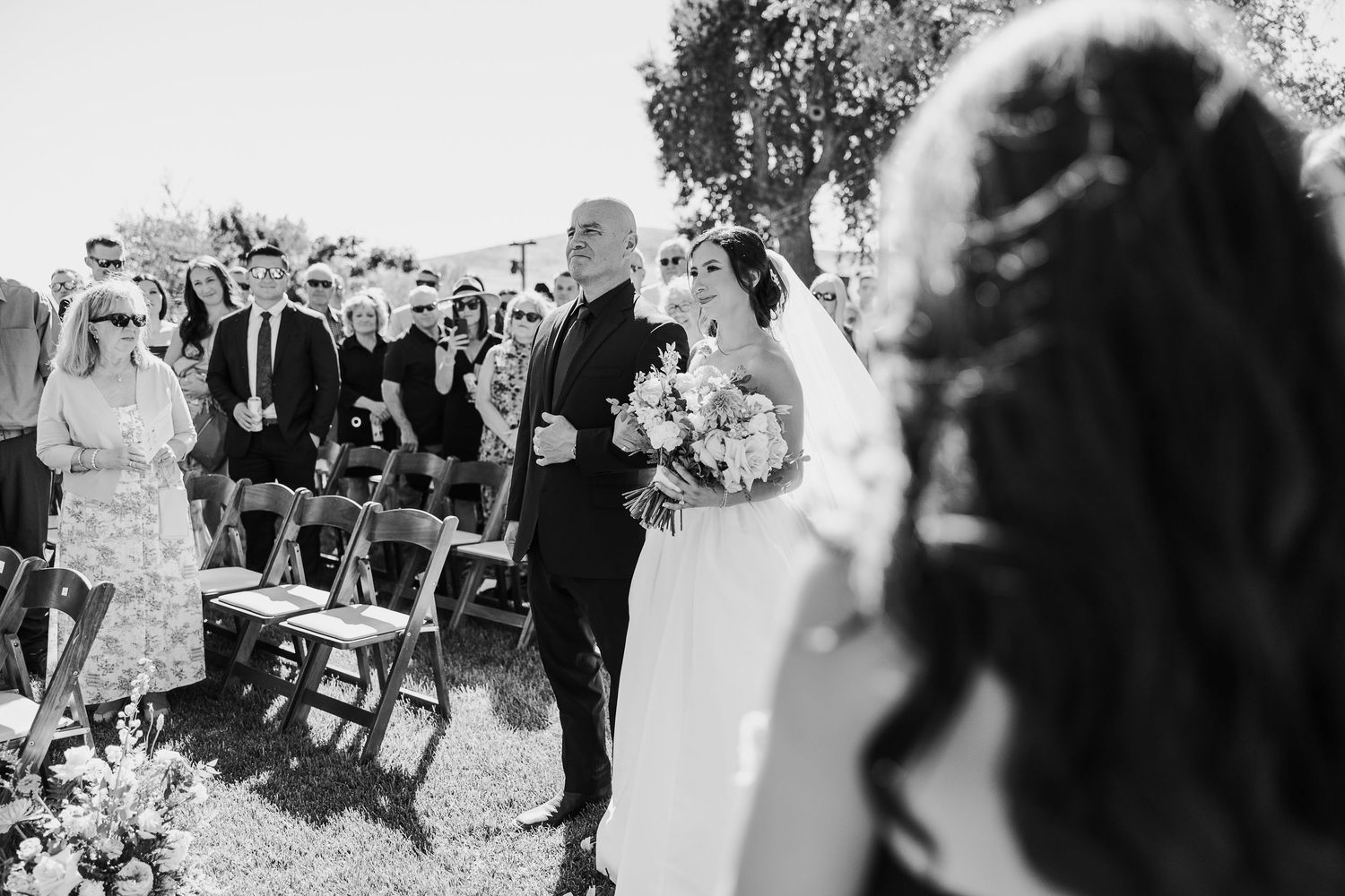 Black and white photo sequence showing candid moments from an outdoor wedding celebration with guests and dancing.