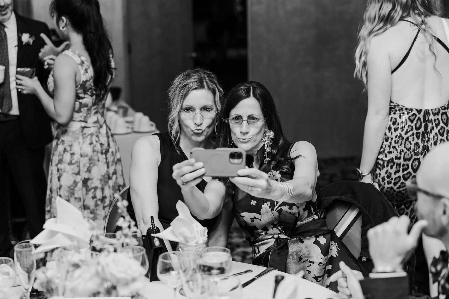 Black and white reception photo showing guests enjoying a celebratory dinner.