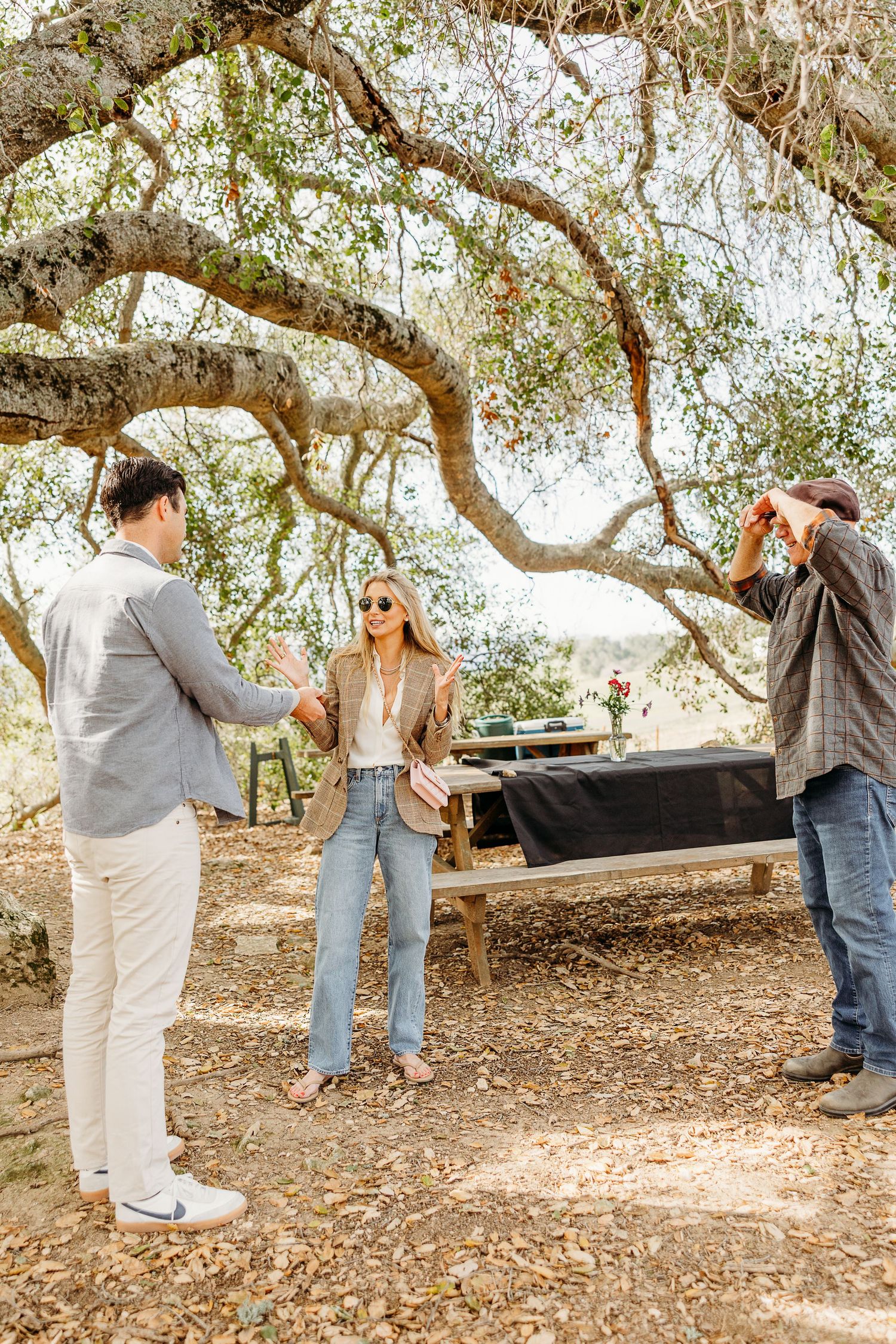 A couple sharing a special moment beneath sprawling oak tree branches.