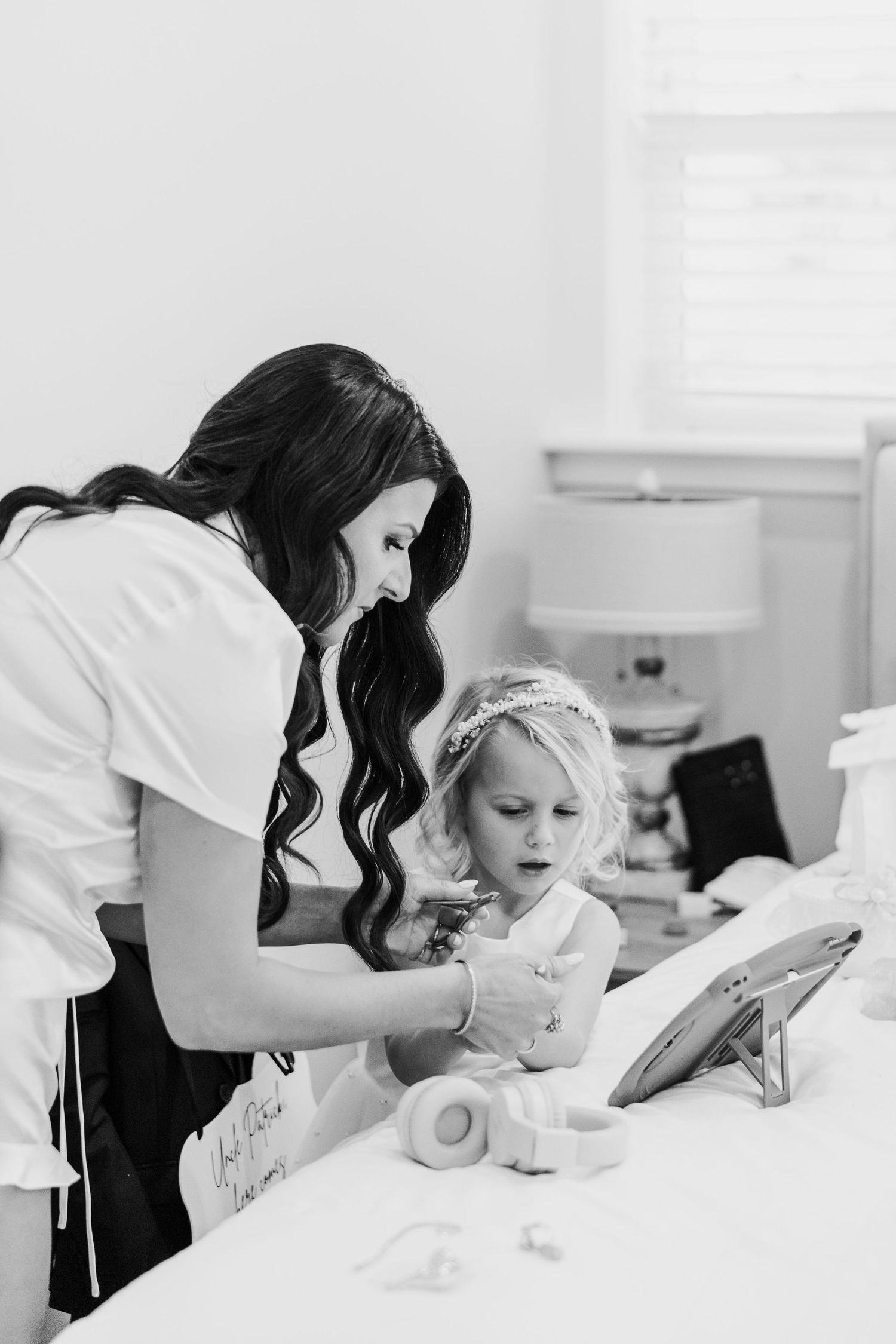 Black and white photo showing someone reading from a tablet device while lying in bed.