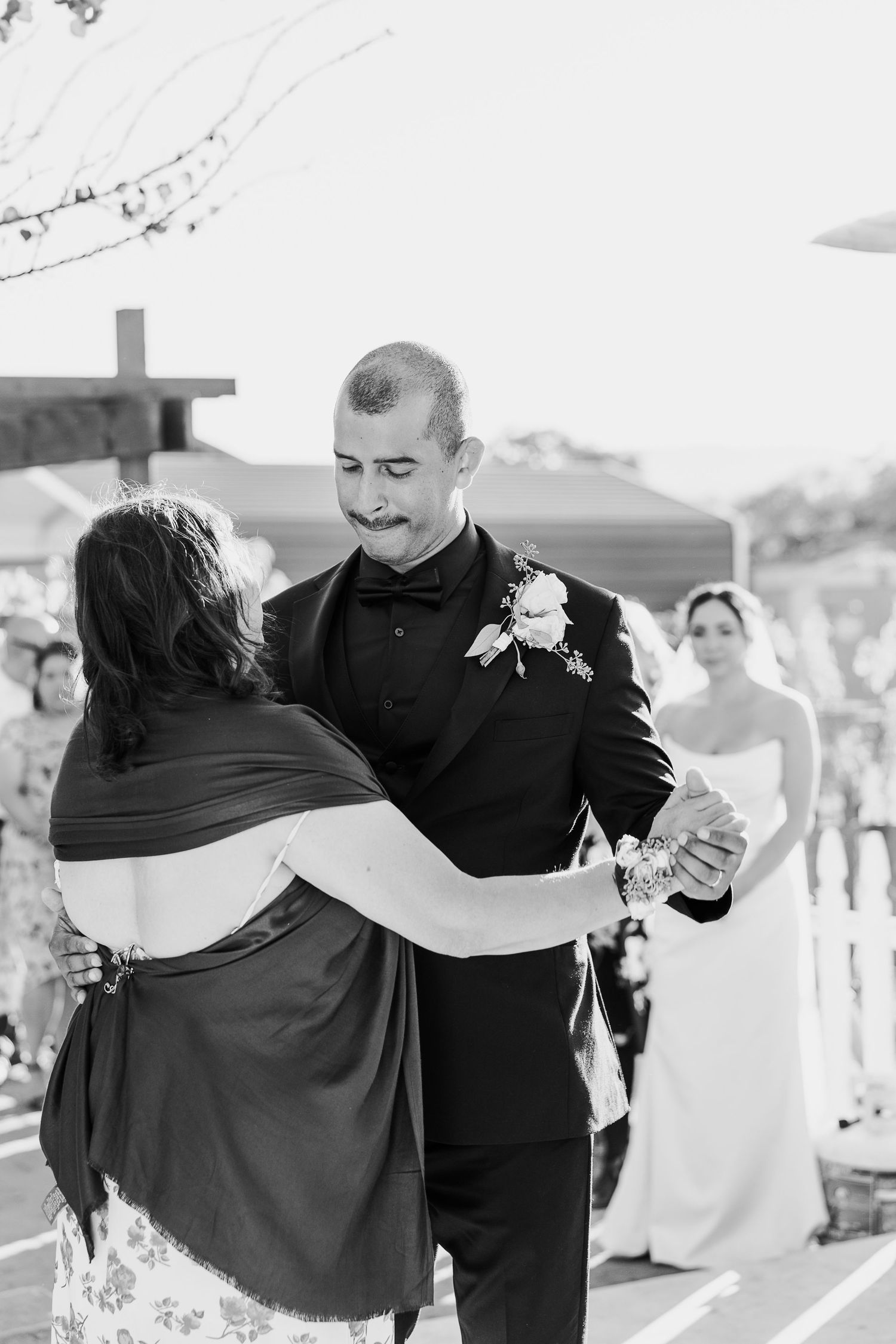 Black and white photos showing joyful dancing and embraces at a wedding reception.
