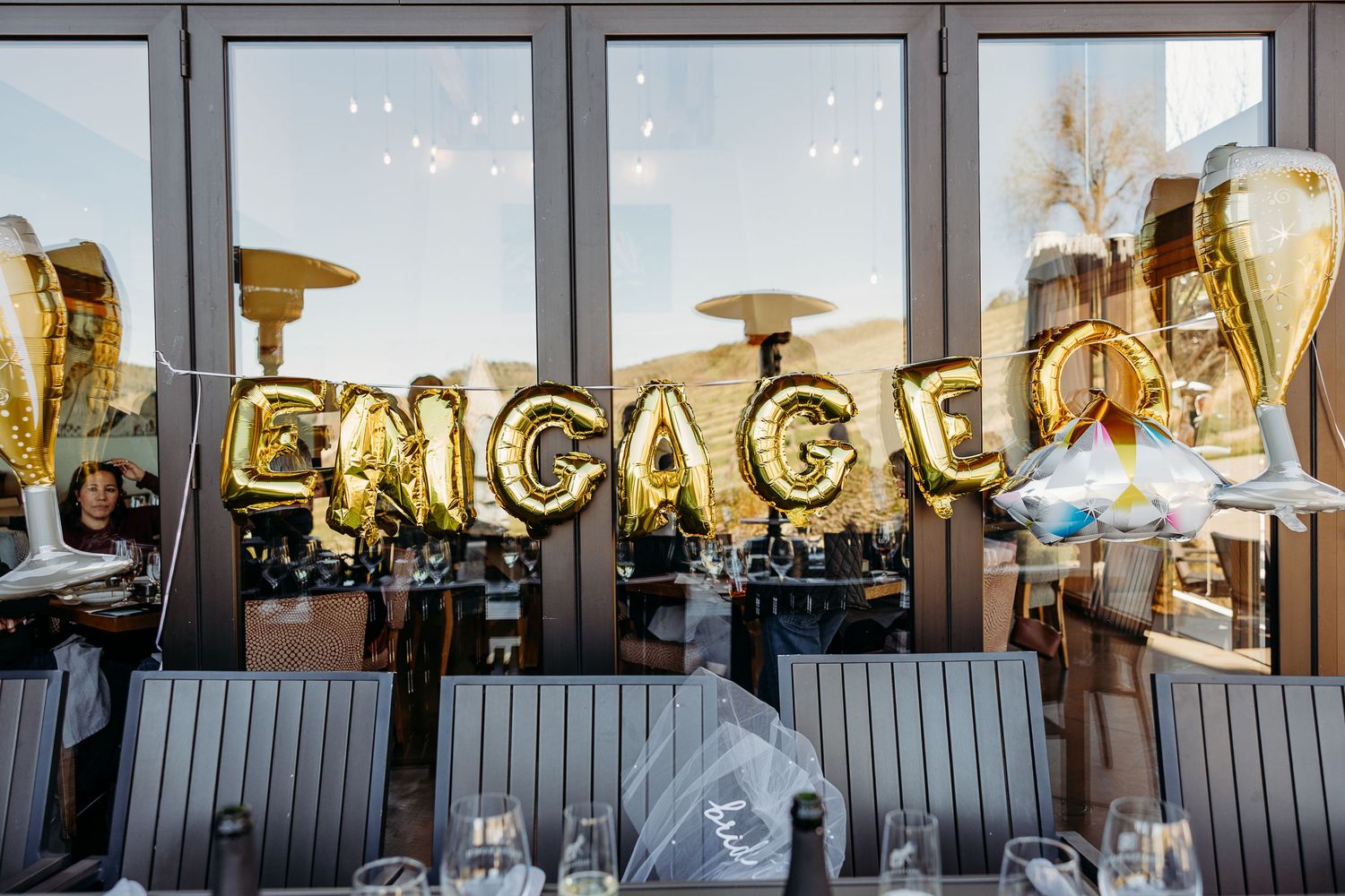 Large windows frame a sunset view with decorative neon signage glowing in the evening light.