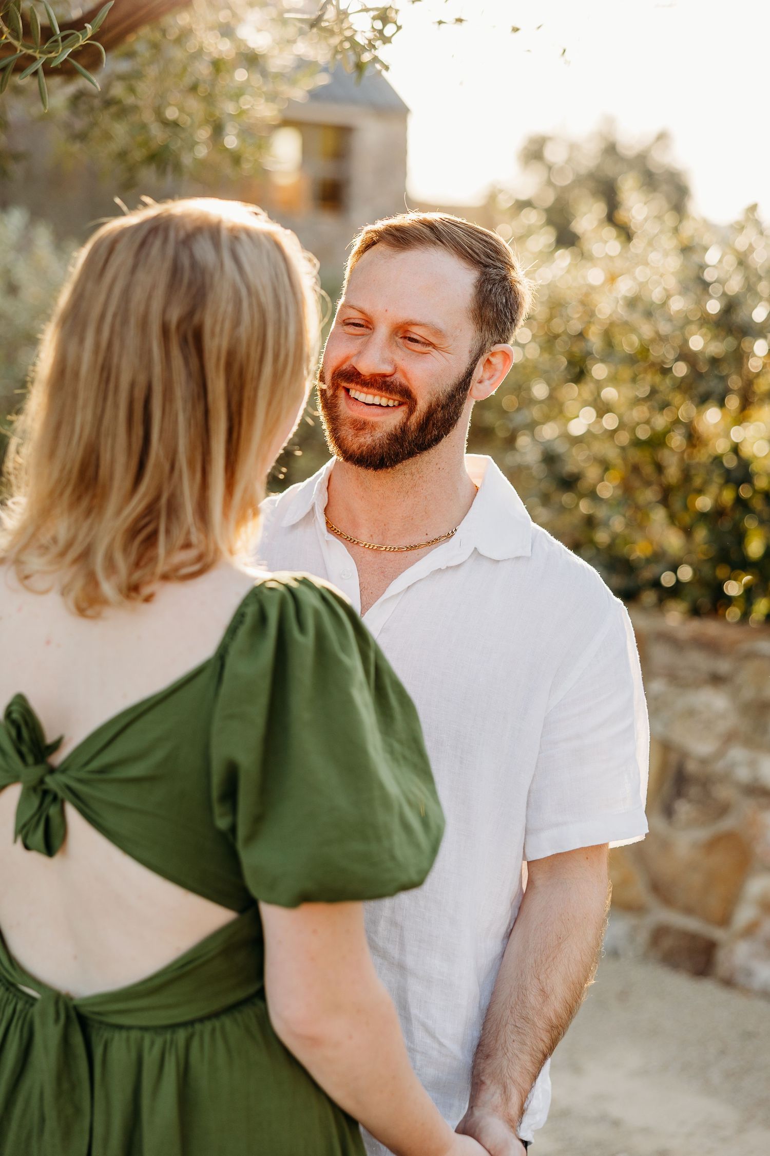 Candid moment between couple laughing together at outdoor winery setting.