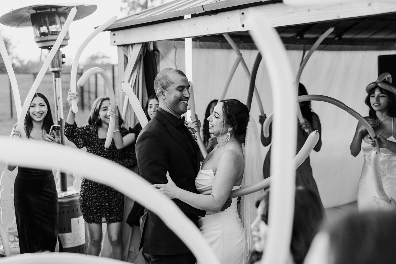 Wedding reception guests dancing and celebrating in black and white.