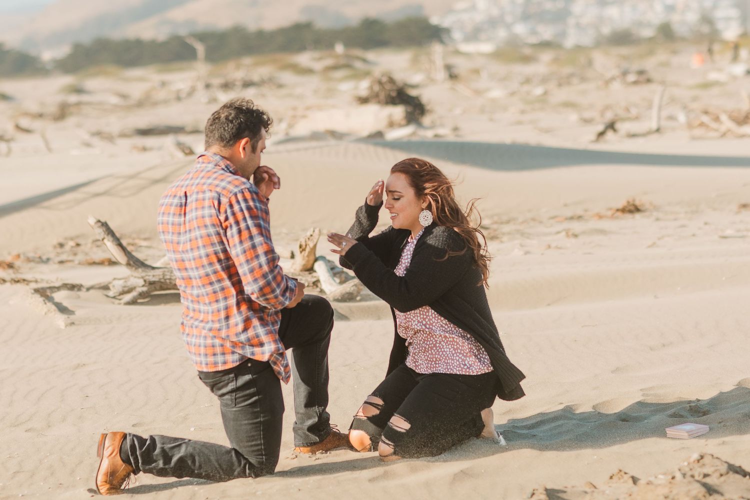 A surprise beach proposal moment captured during sunset.