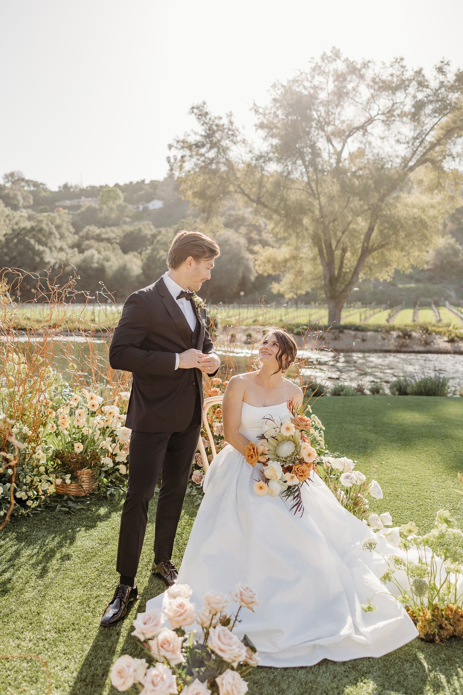 A couple shares romantic moments in a garden setting with colorful flowers and natural sunlight.