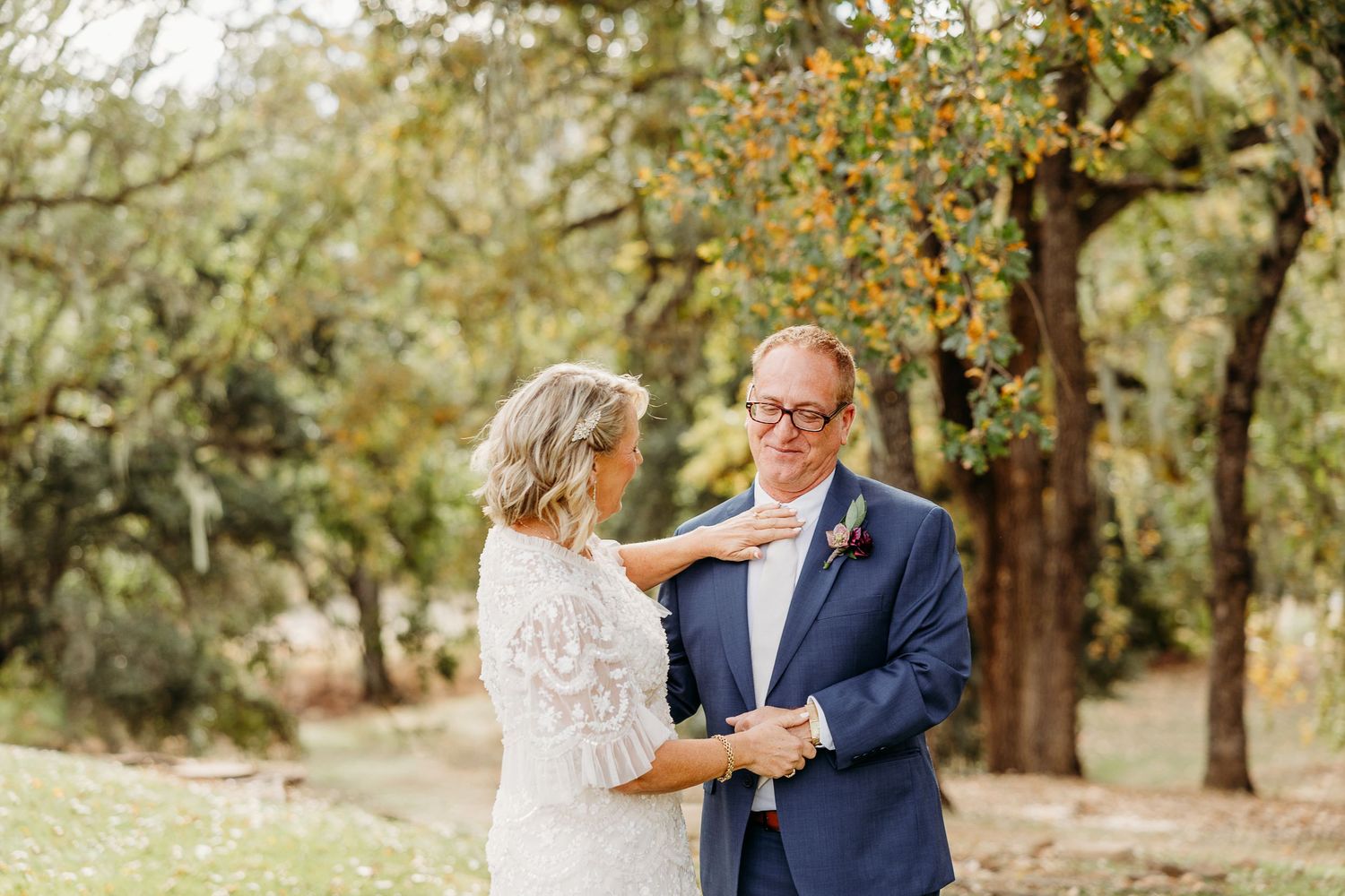 Couple dancing together in a wooded outdoor setting during autumn.