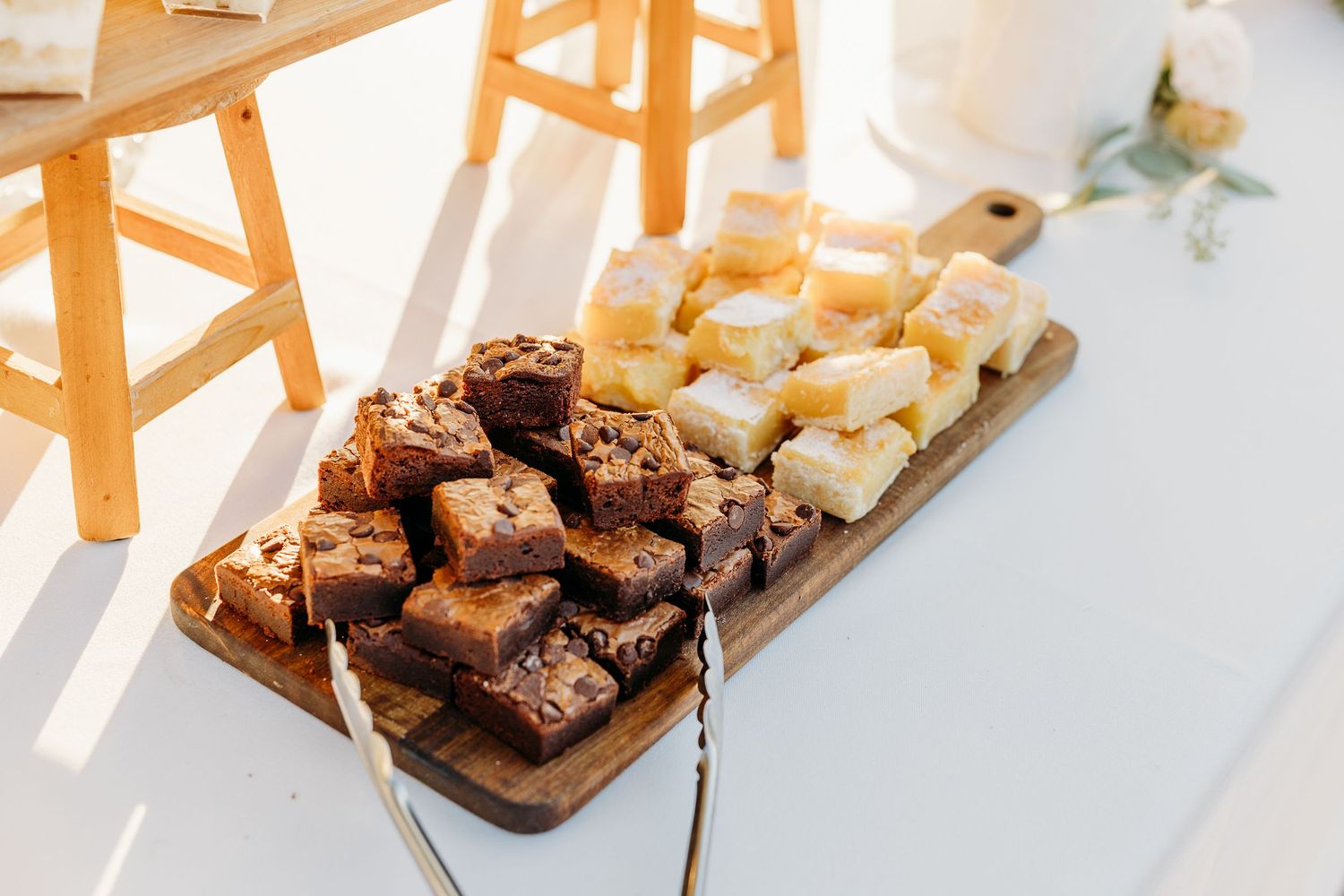 Wooden serving boards with assorted appetizers at outdoor wedding reception.