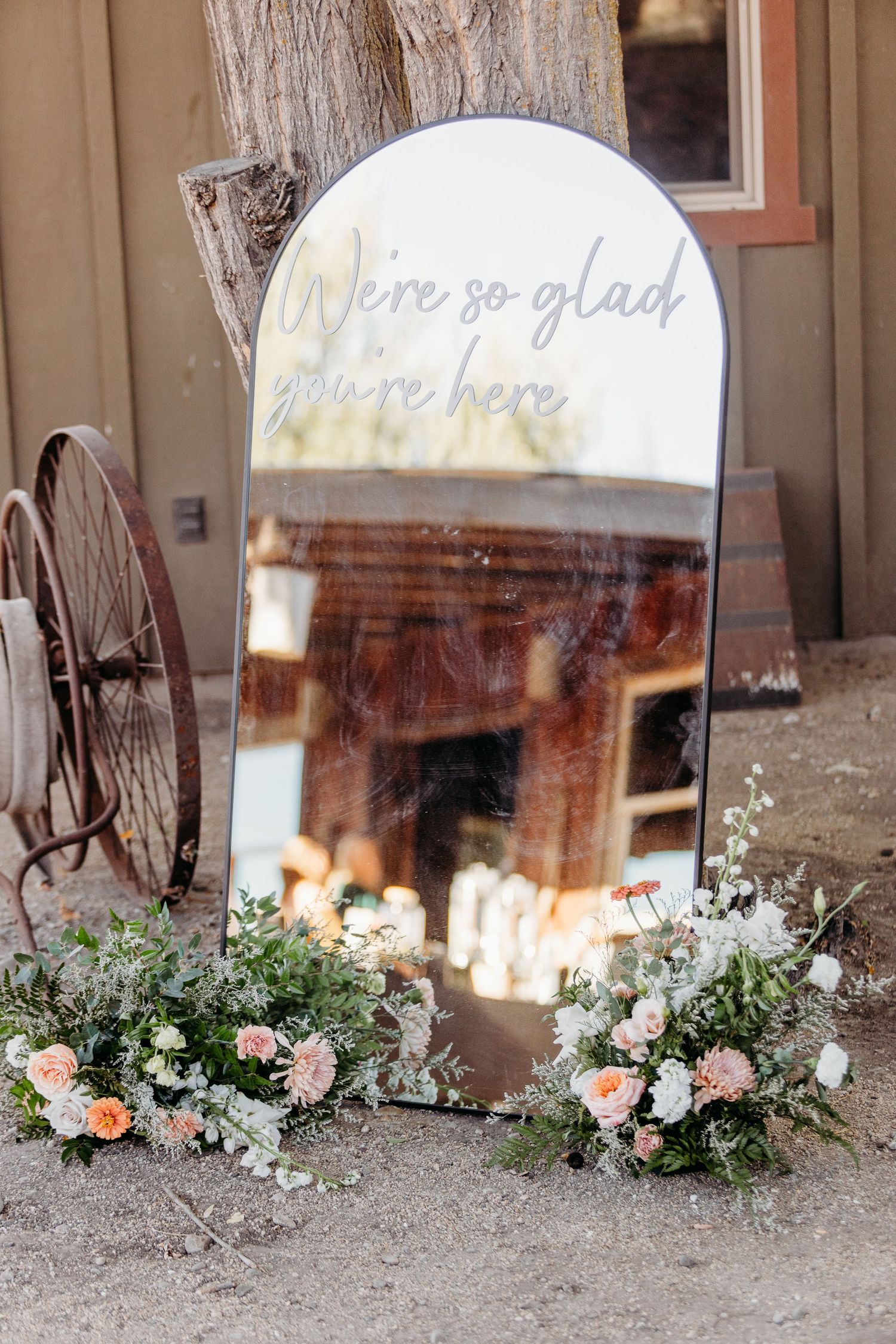 Decorative floral arrangements with pink and white flowers displayed in front of reflective glass windows.