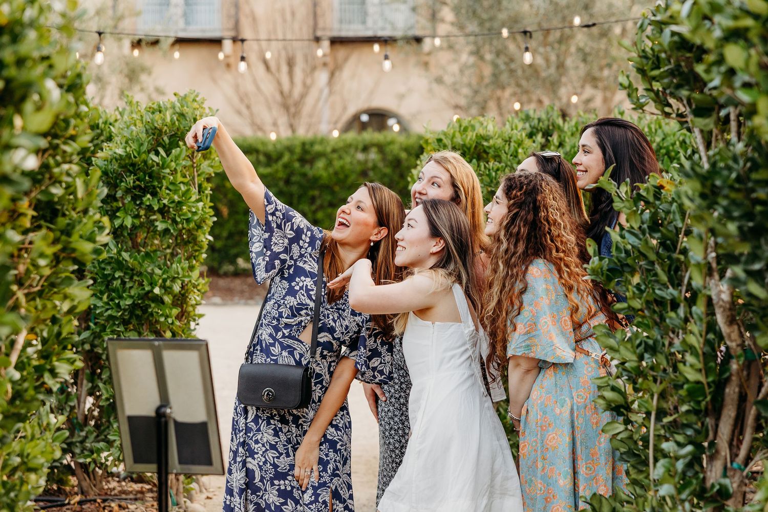 Friends enjoying a casual outdoor gathering with natural garden backdrop.