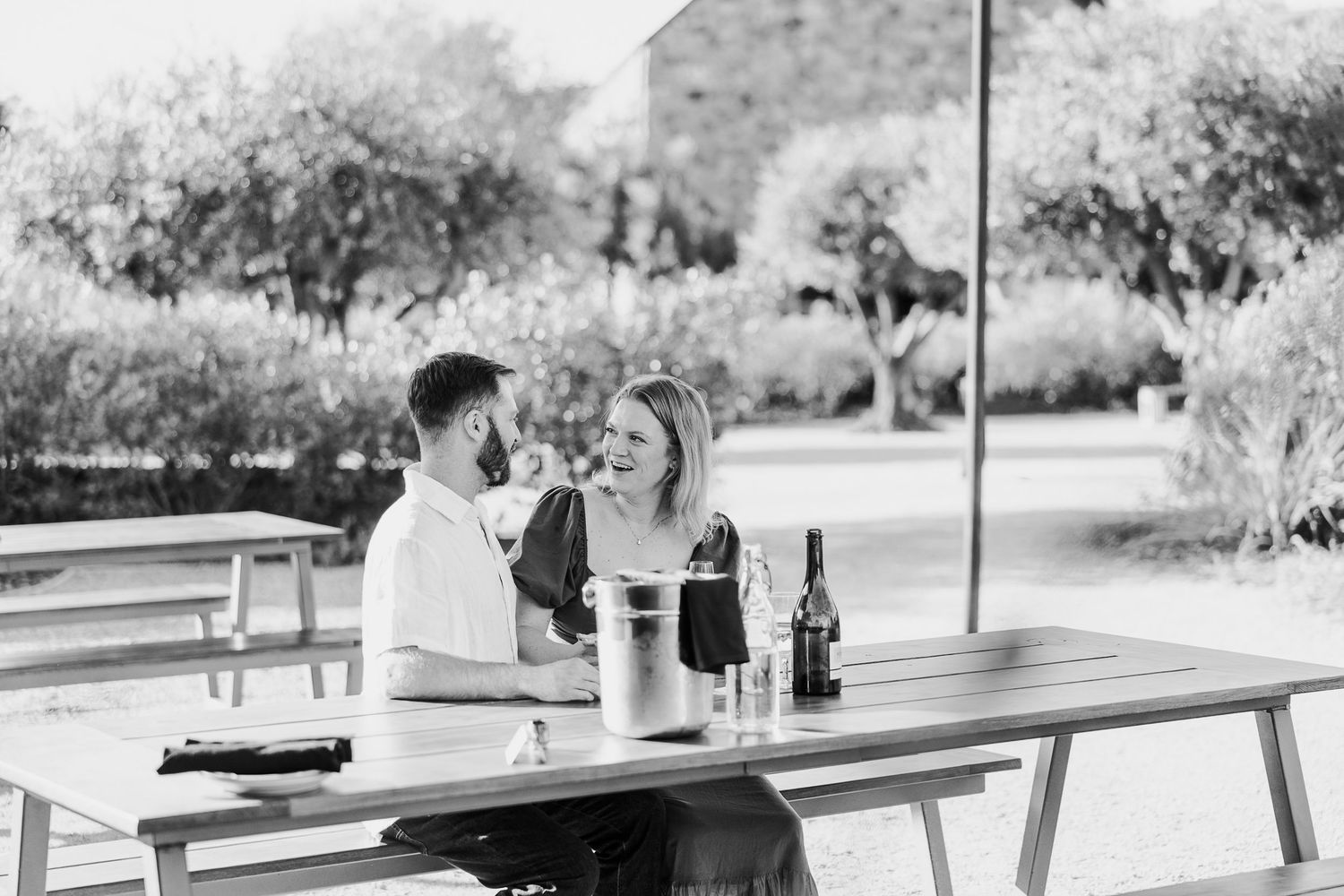 A black and white film strip showing a sequence of outdoor wedding moments at a garden venue.