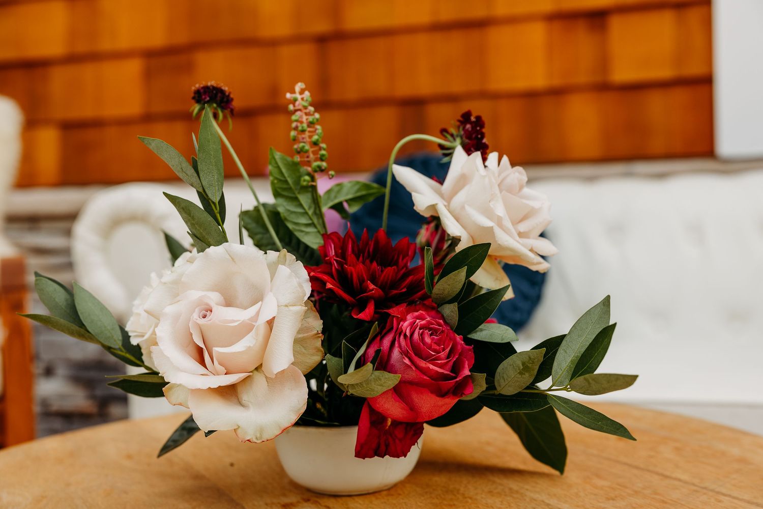 Elegant floral arrangements featuring red and pink roses with greenery in glass vases.
