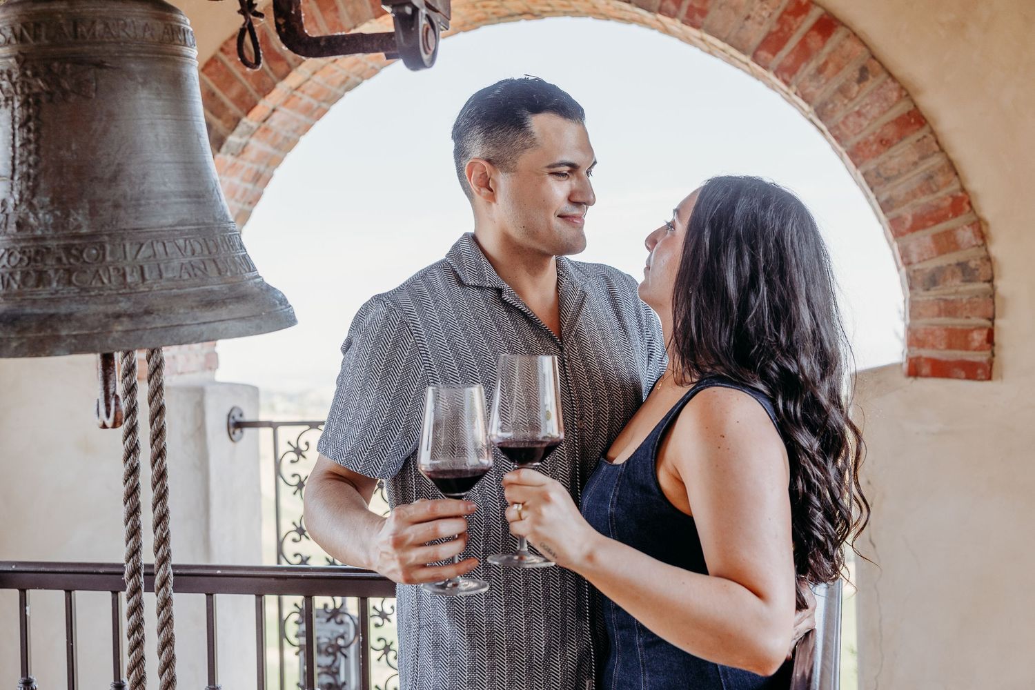 A romantic moment under brick archways with natural light streaming in.